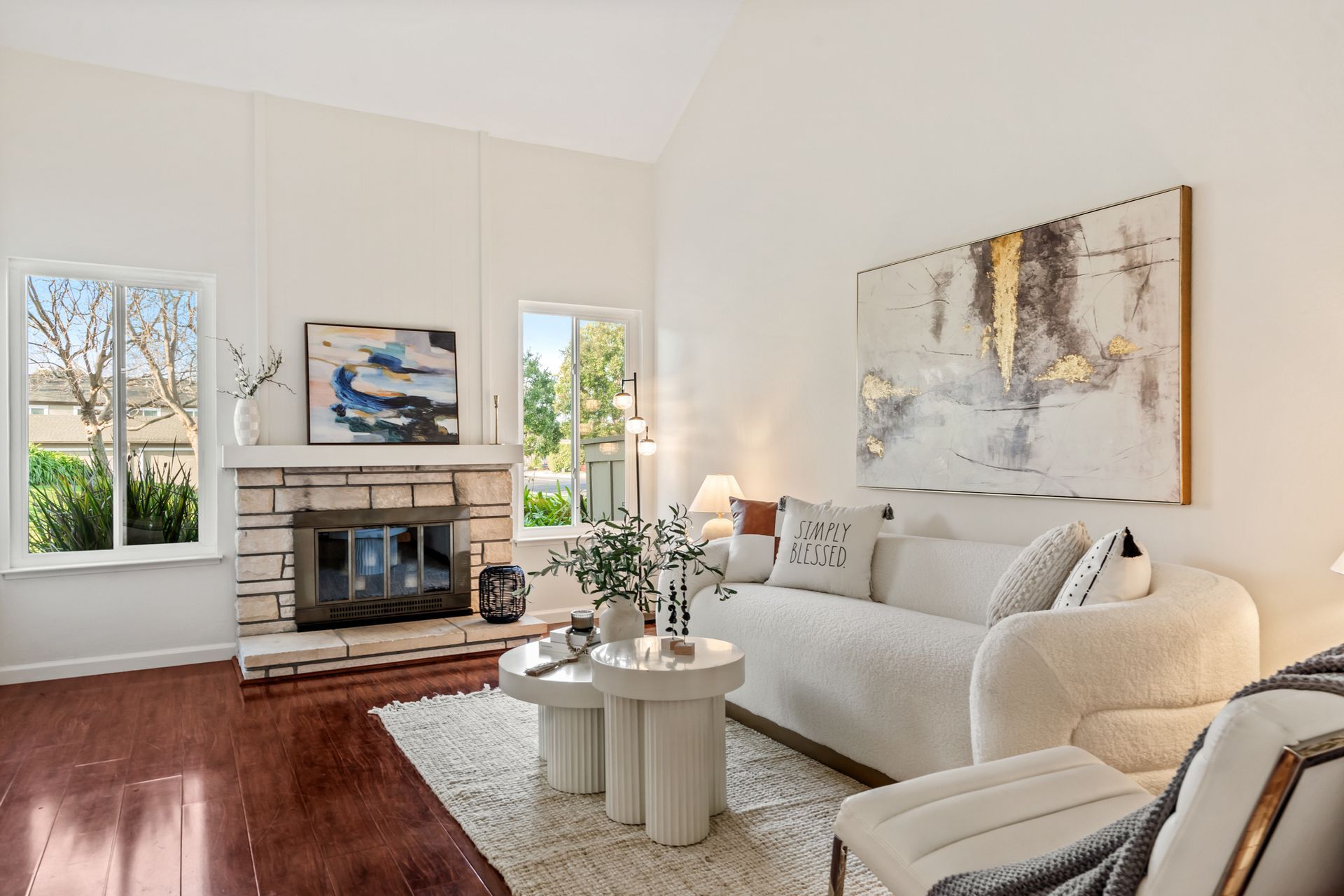 A living room with a couch , chair , table and fireplace.