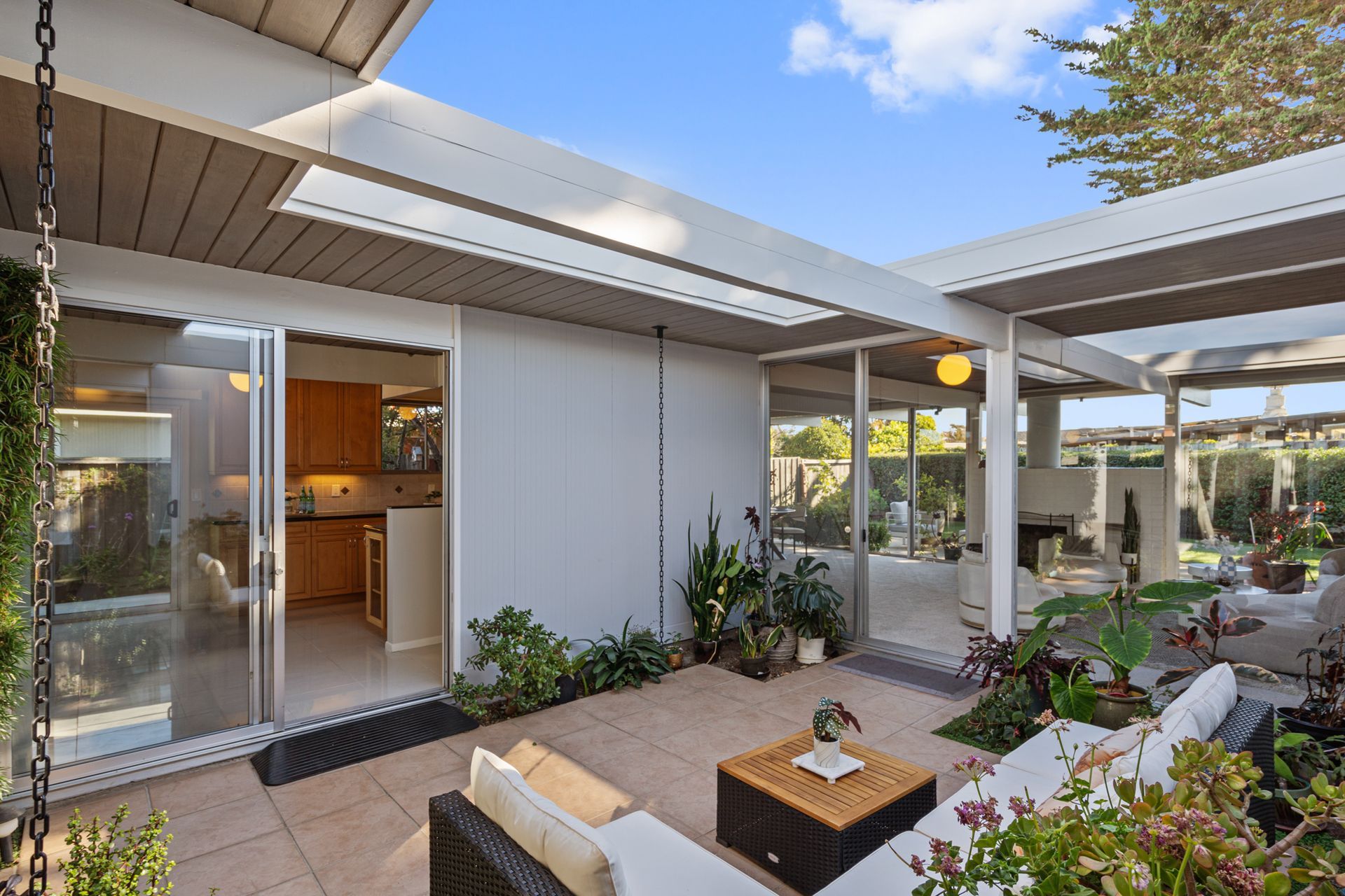 A patio with a couch and a table in front of a house