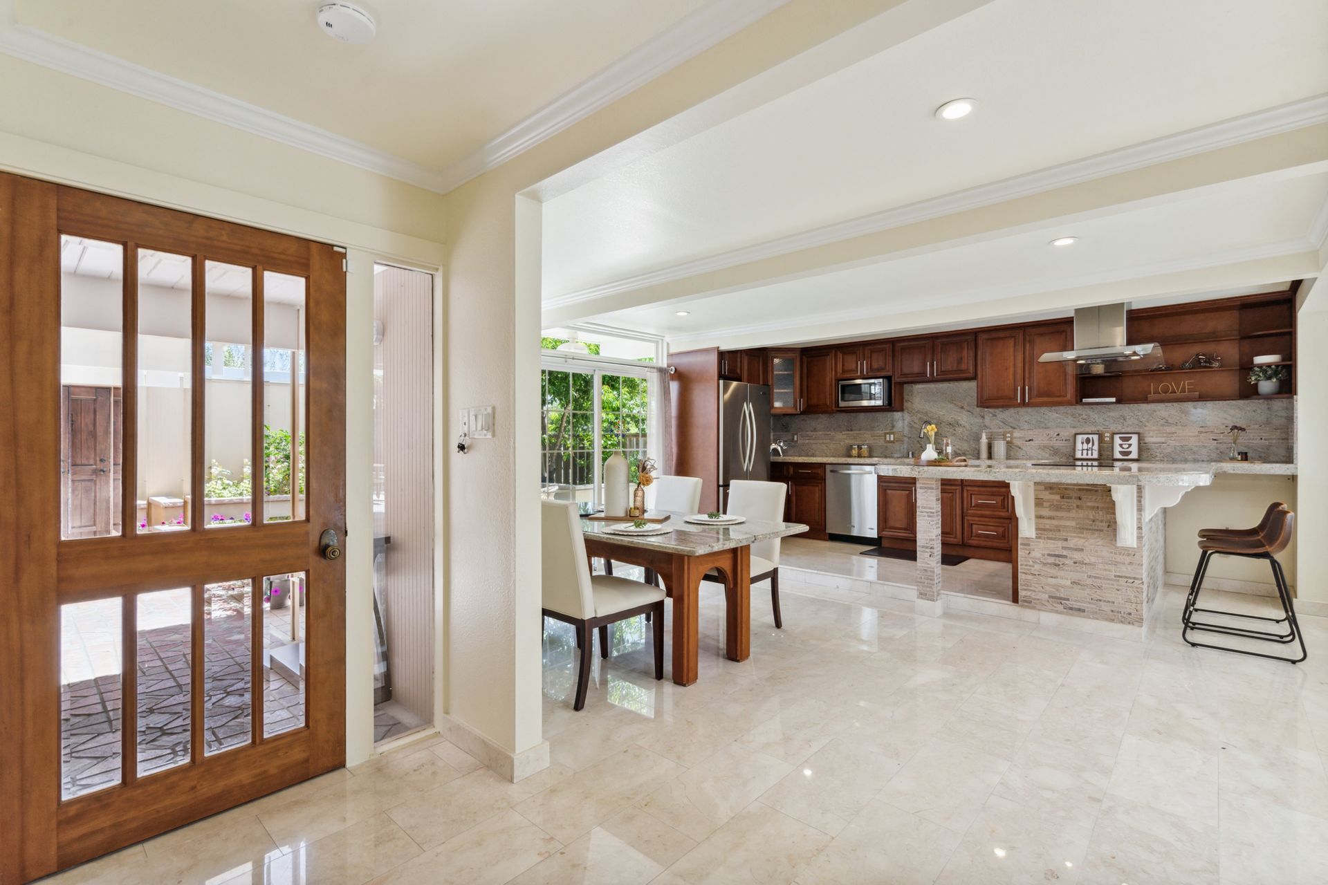 A kitchen and dining room in a house with a table and chairs.