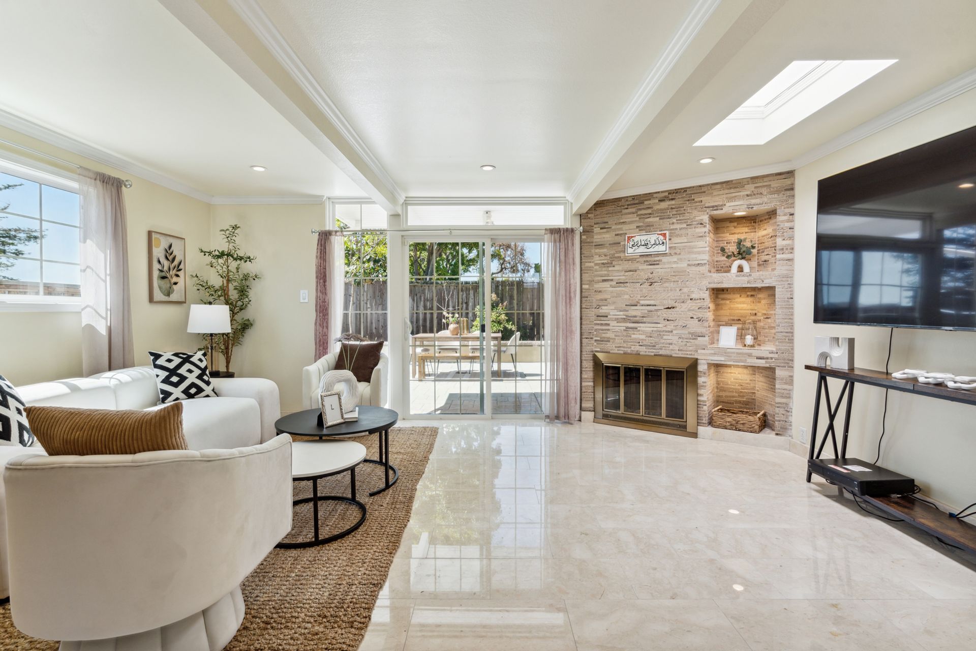 A living room with a couch , chairs , a fireplace and a flat screen tv.