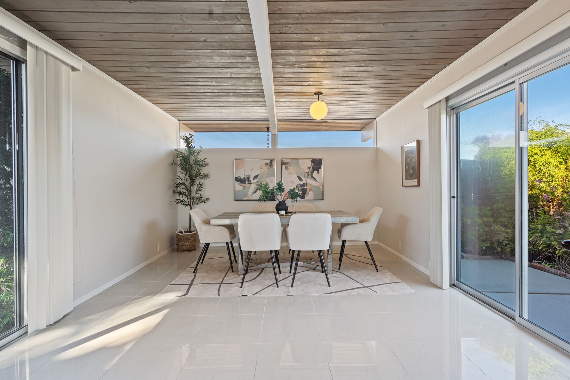 A dining room with a table and chairs and sliding glass doors.