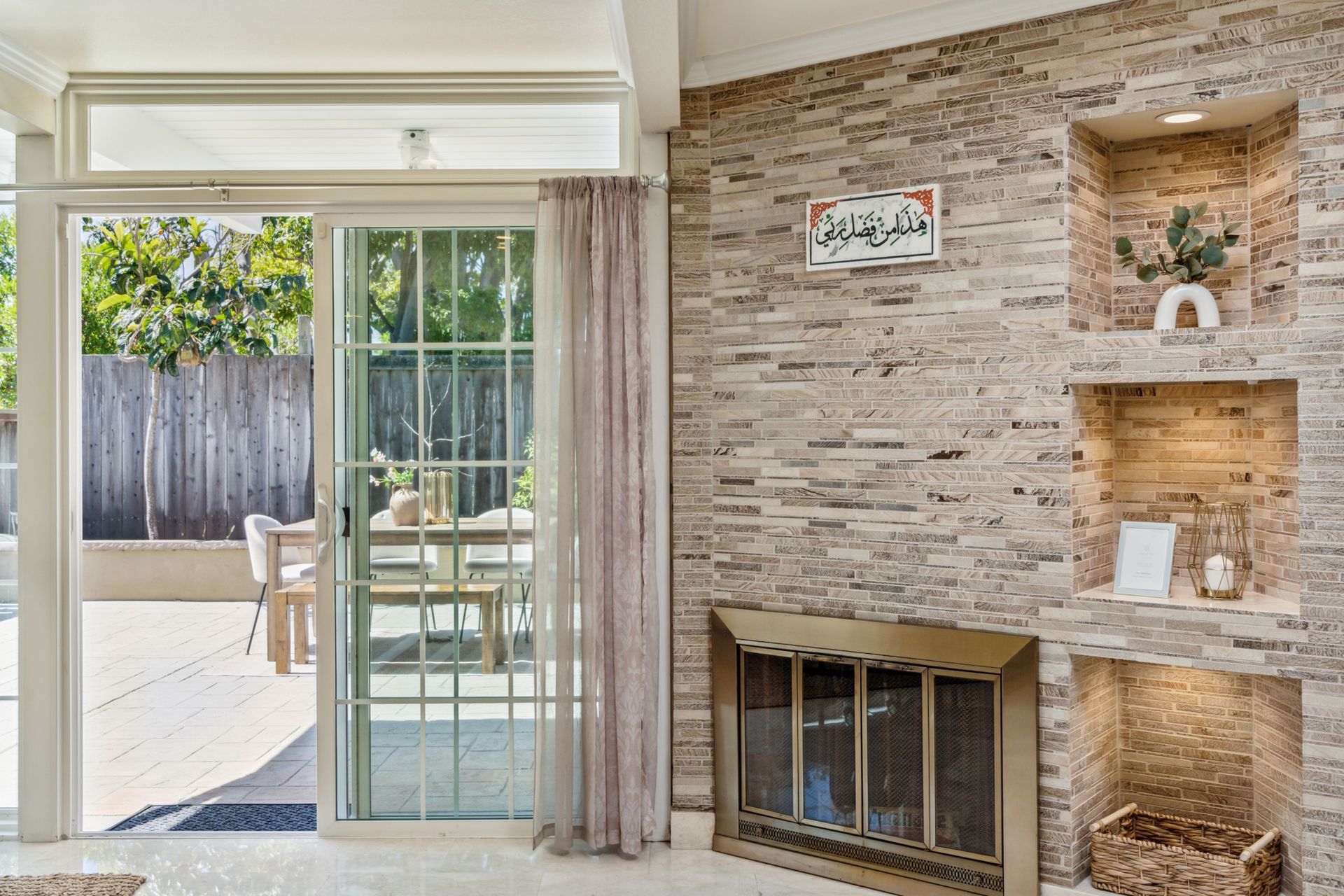 A living room with a fireplace and a sliding glass door leading to a patio.