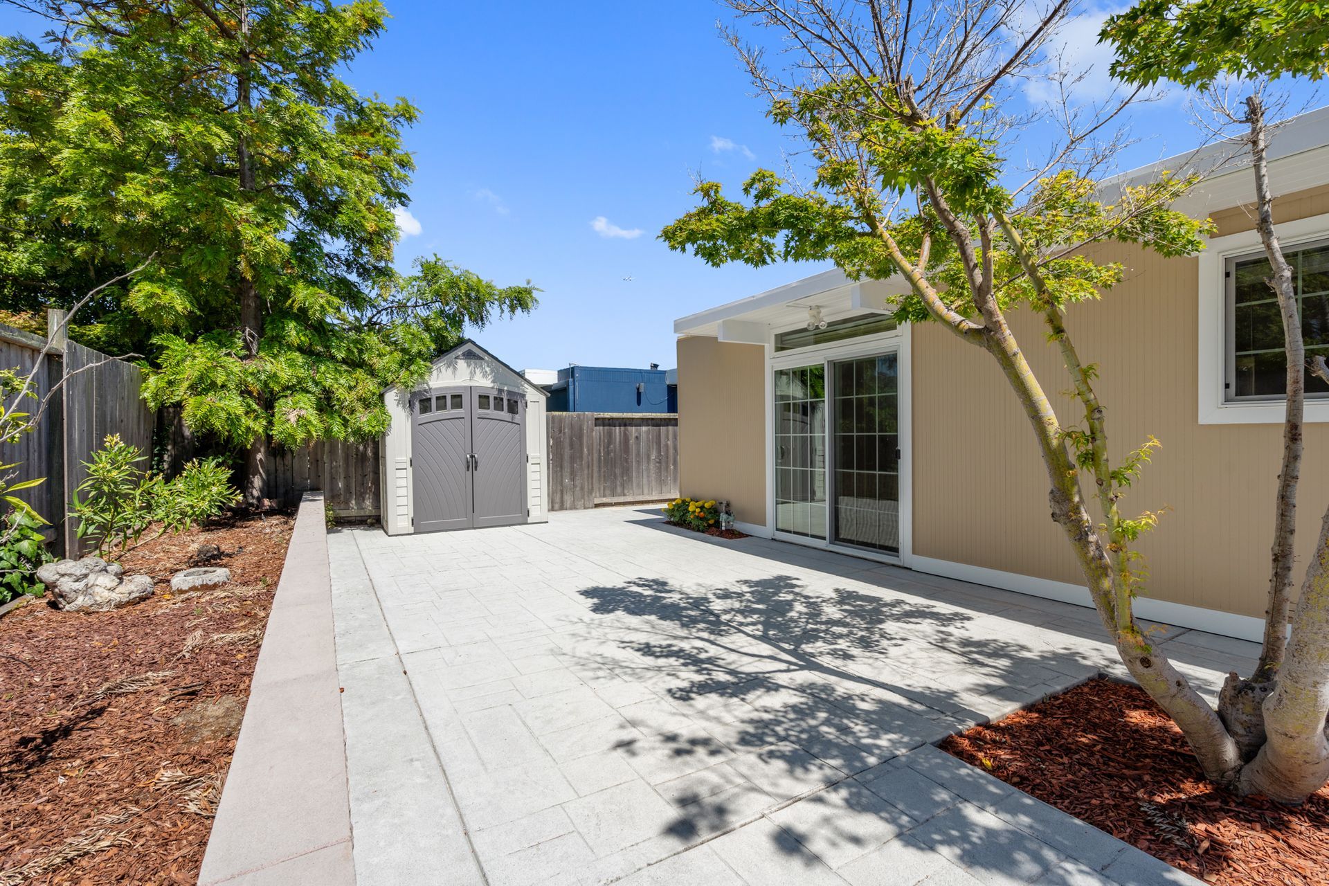The backyard of a house with a patio and a garage.