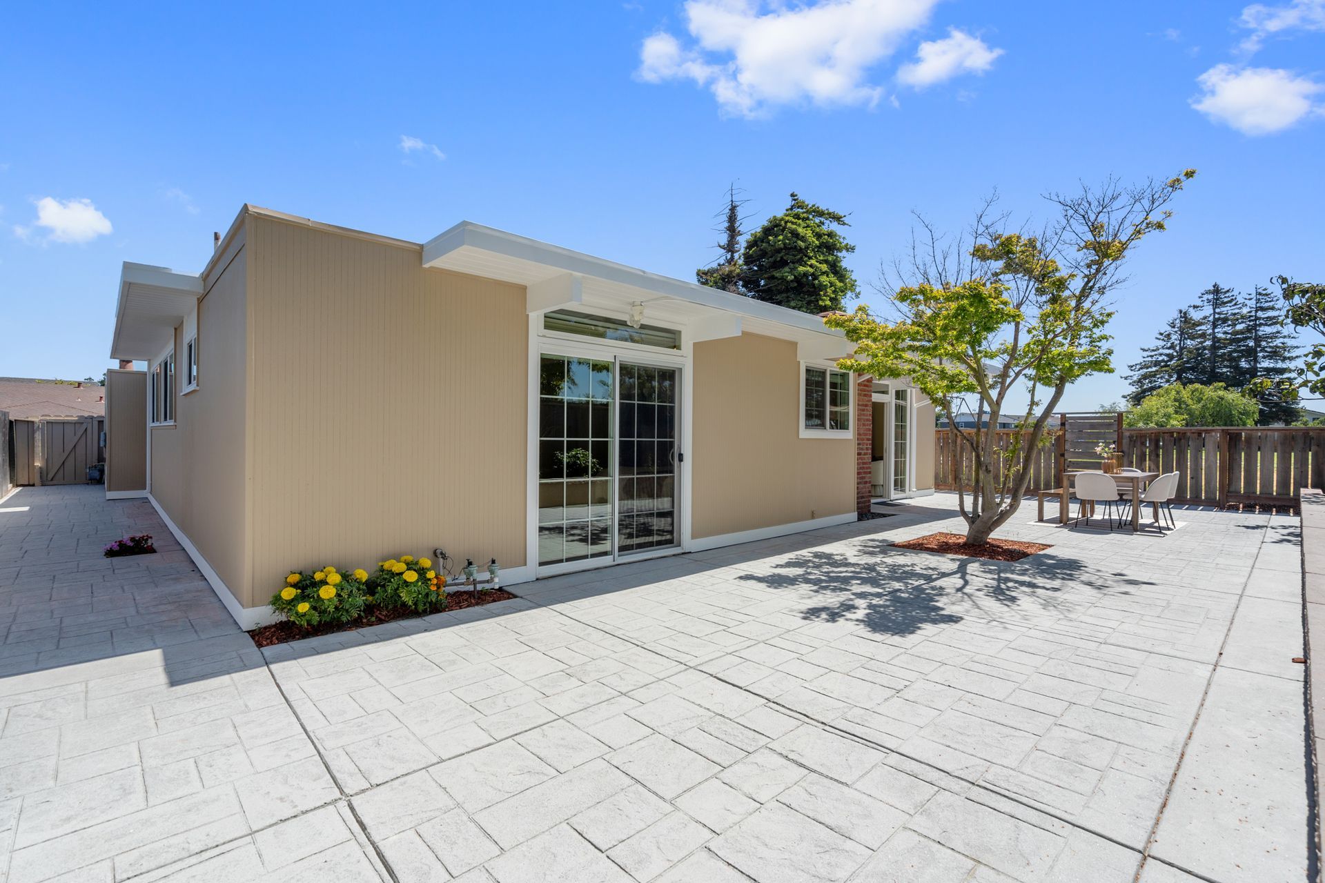 A house with a patio and a tree in front of it