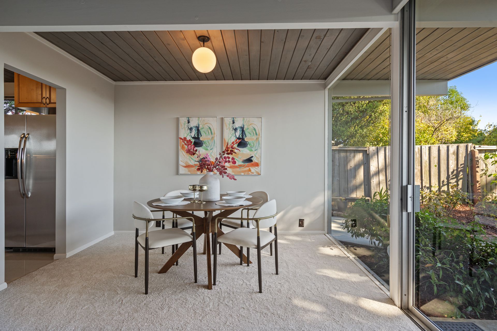 A dining room with a table and chairs and a sliding glass door.