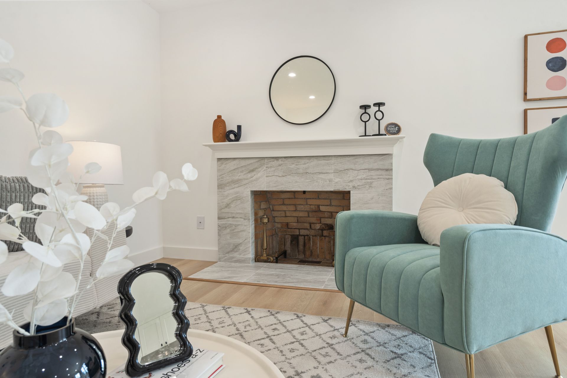 A living room with a chair , fireplace and mirror.