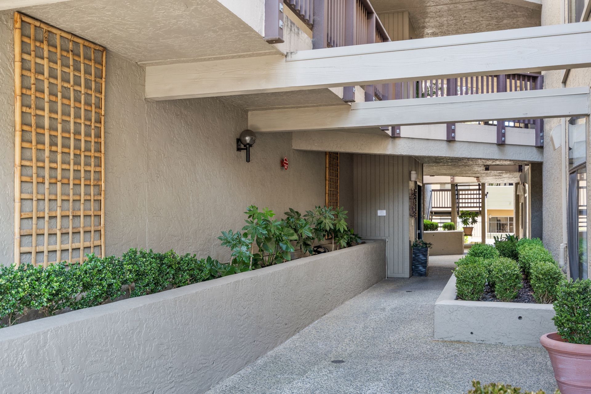 A building with a walkway and planters in front of it