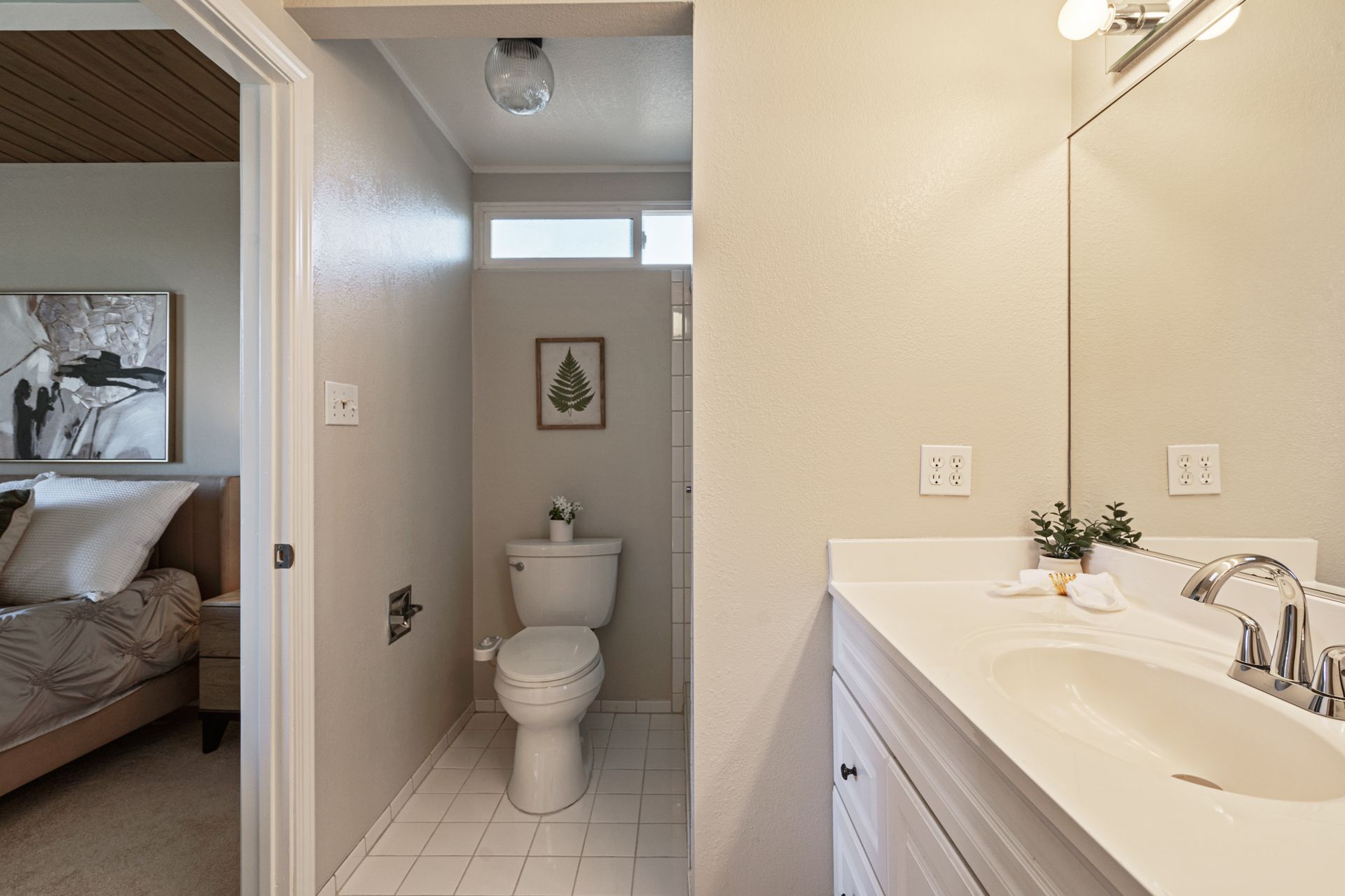 A bathroom with a toilet , sink and mirror.