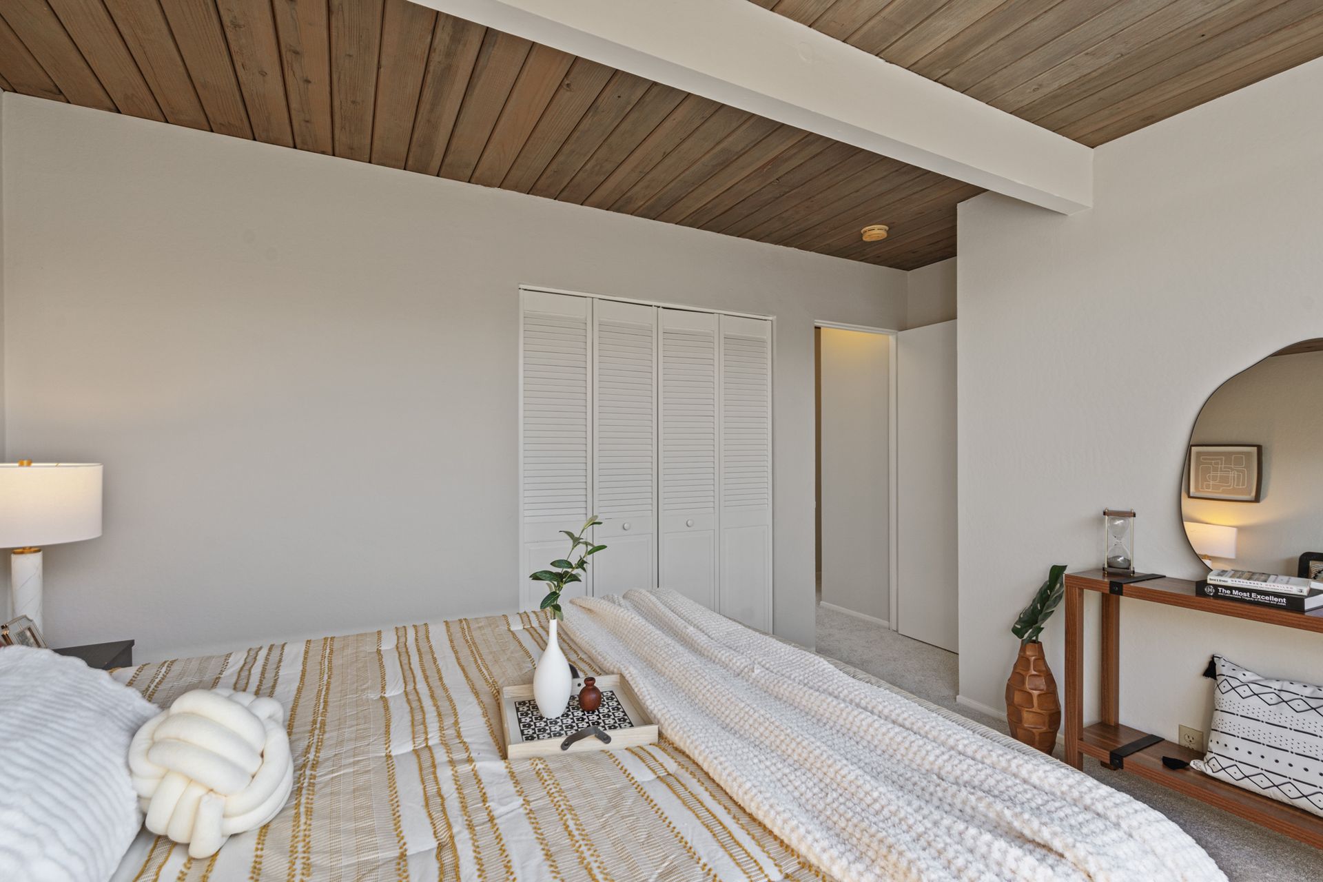 A bedroom with a king size bed and a wooden ceiling.