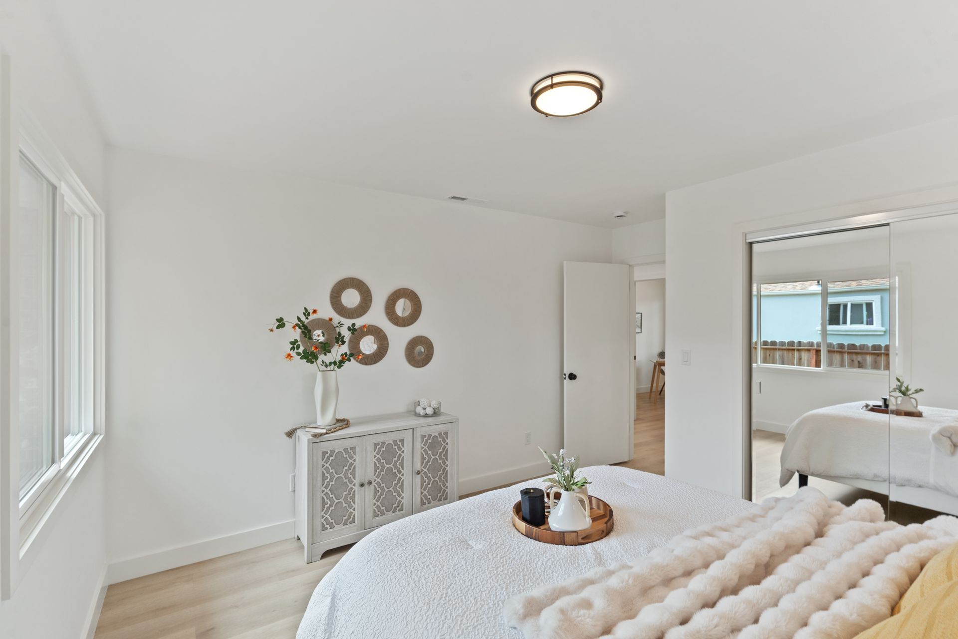 A bedroom with a bed , dresser , and window.