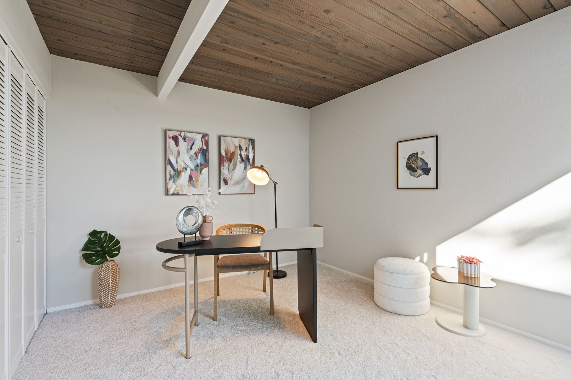 A home office with a desk , chair and lamp.