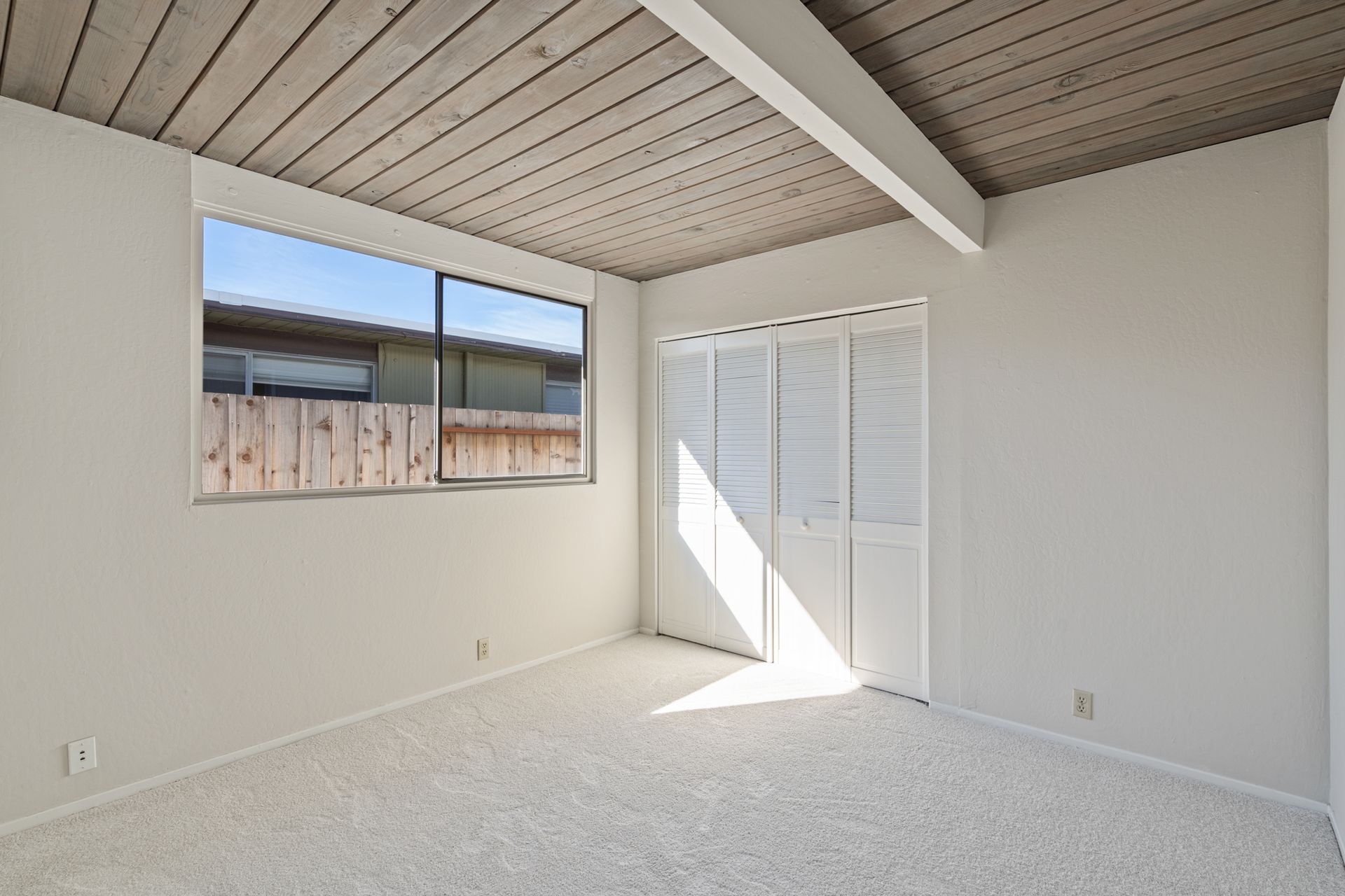 An empty room with white walls and a window