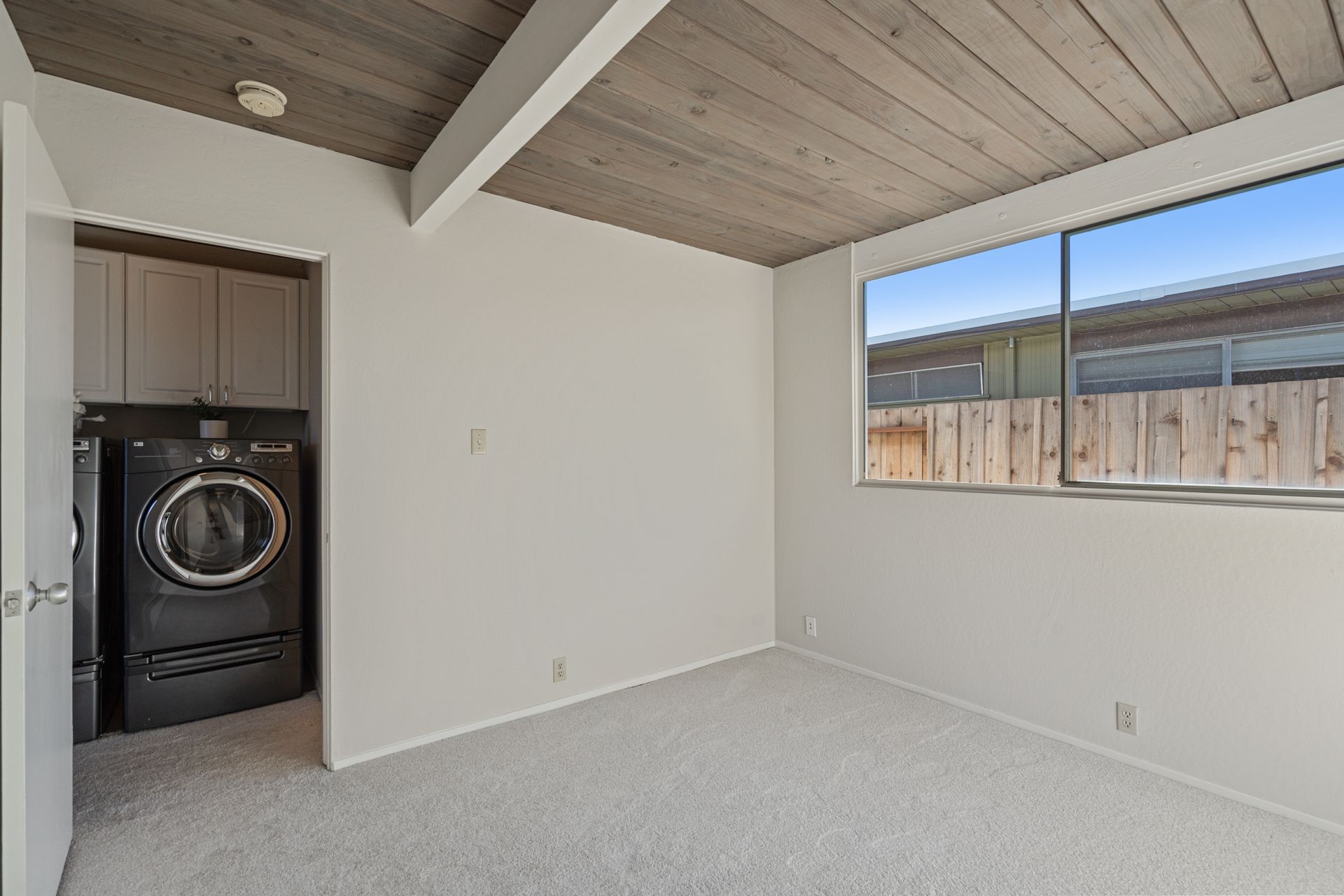 An empty room with a washer and dryer in it.