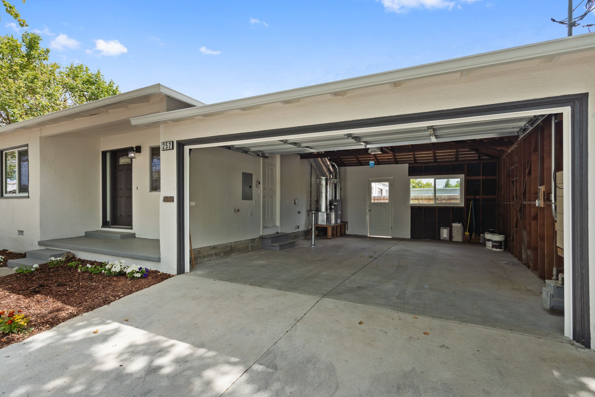 A house with a garage and a driveway in front of it.