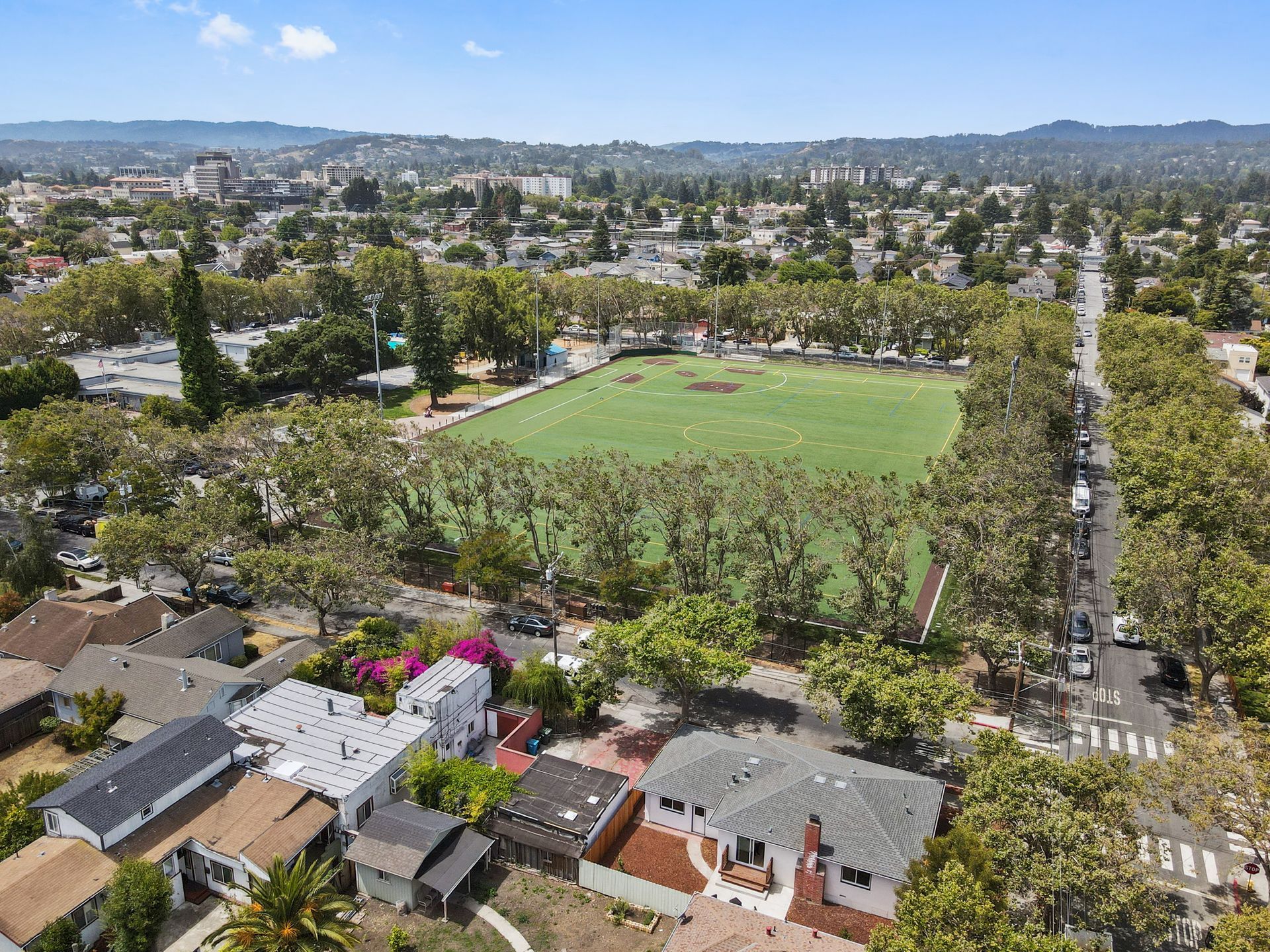 An aerial view of a residential area with a baseball field in the middle.
