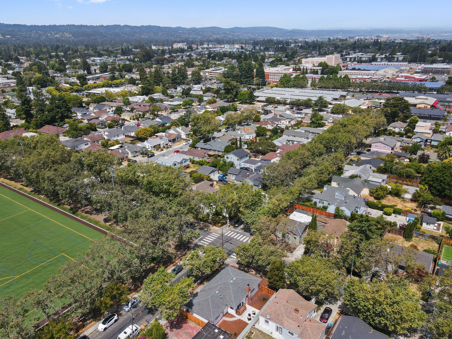 An aerial view of a residential area with a soccer field in the foreground.