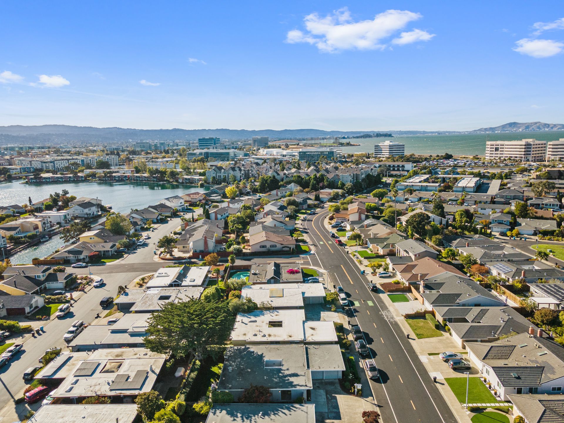An aerial view of a residential neighborhood with a lake in the background.