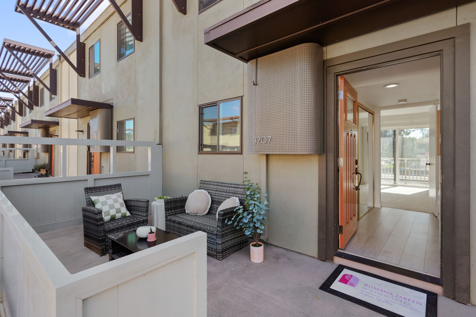 A patio with a couch and chairs in front of a building
