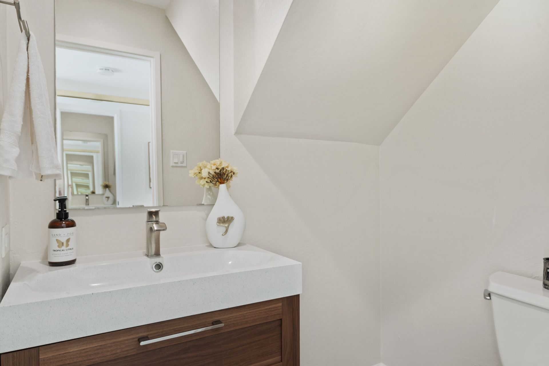 A bathroom with a sink , toilet and mirror.