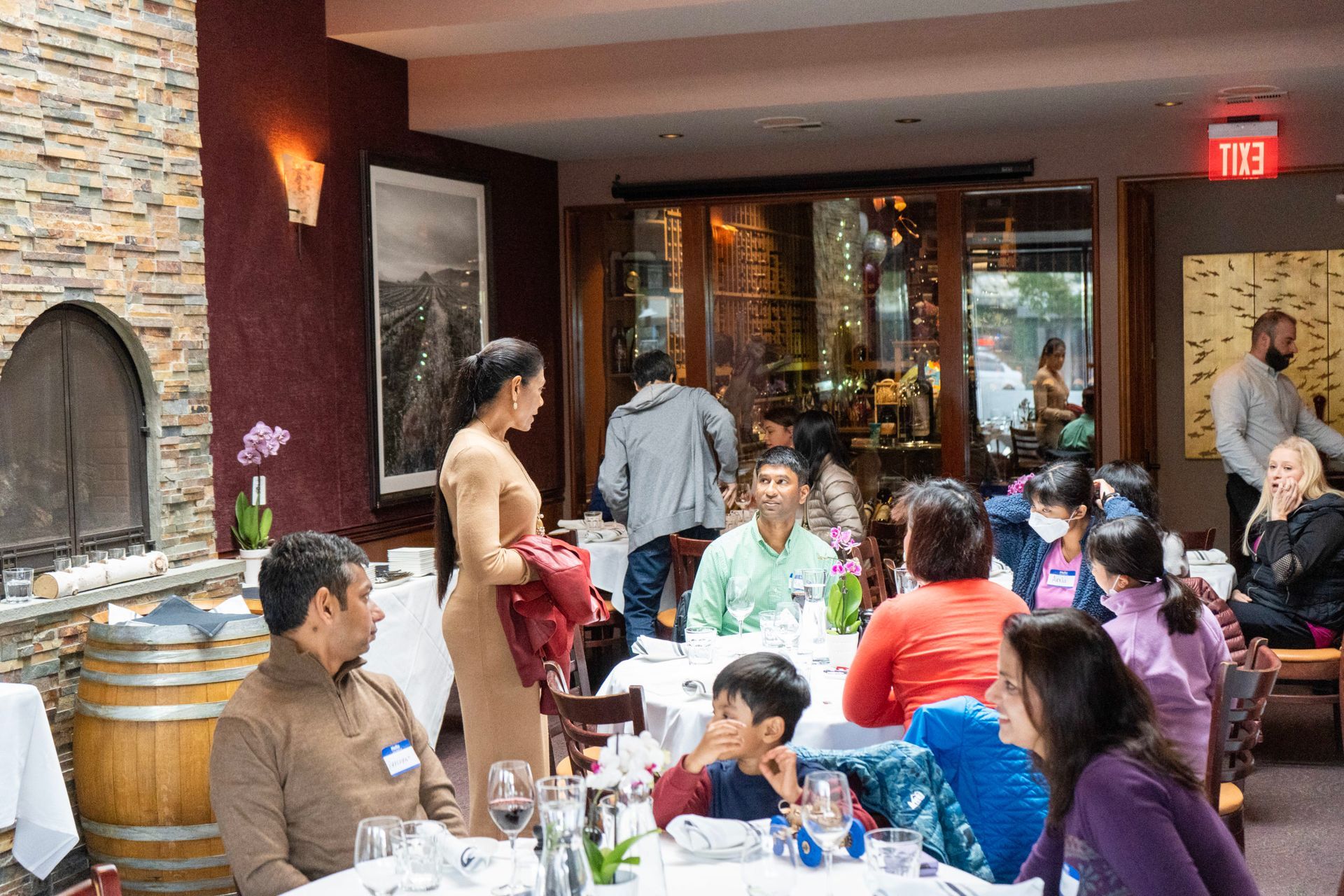 A group of people are sitting at tables in a restaurant.
