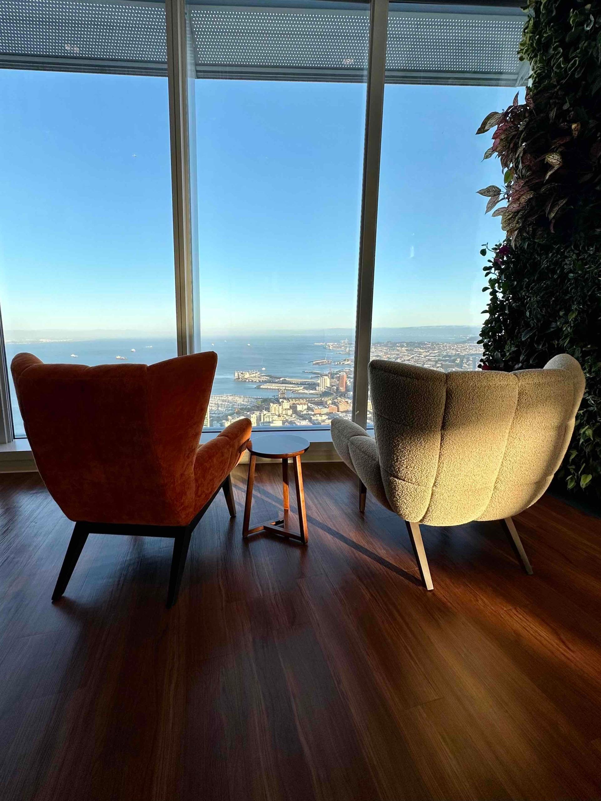 Two chairs are sitting in front of a large window with a view of the city.