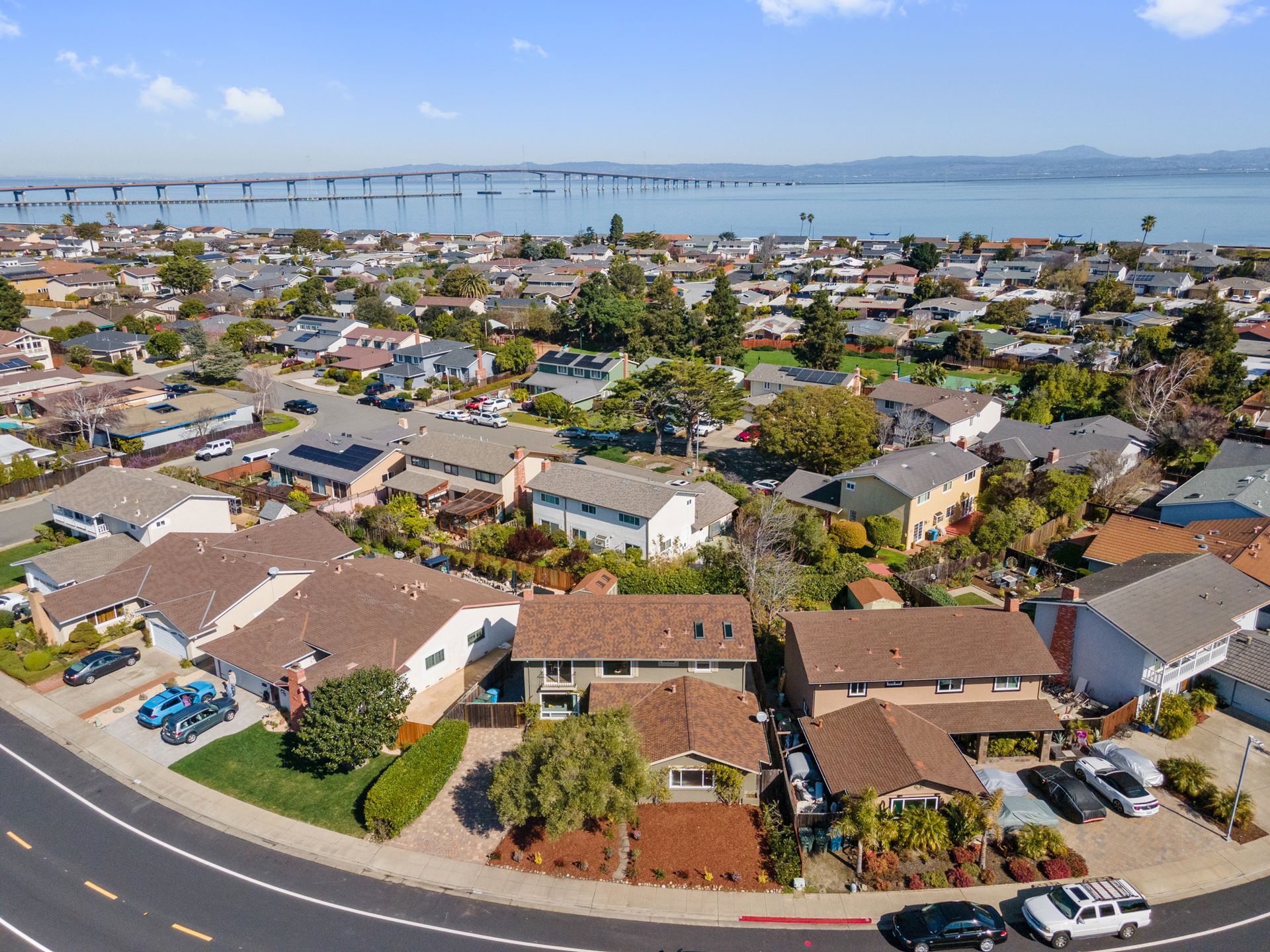 An aerial view of a residential area with a bridge in the background.