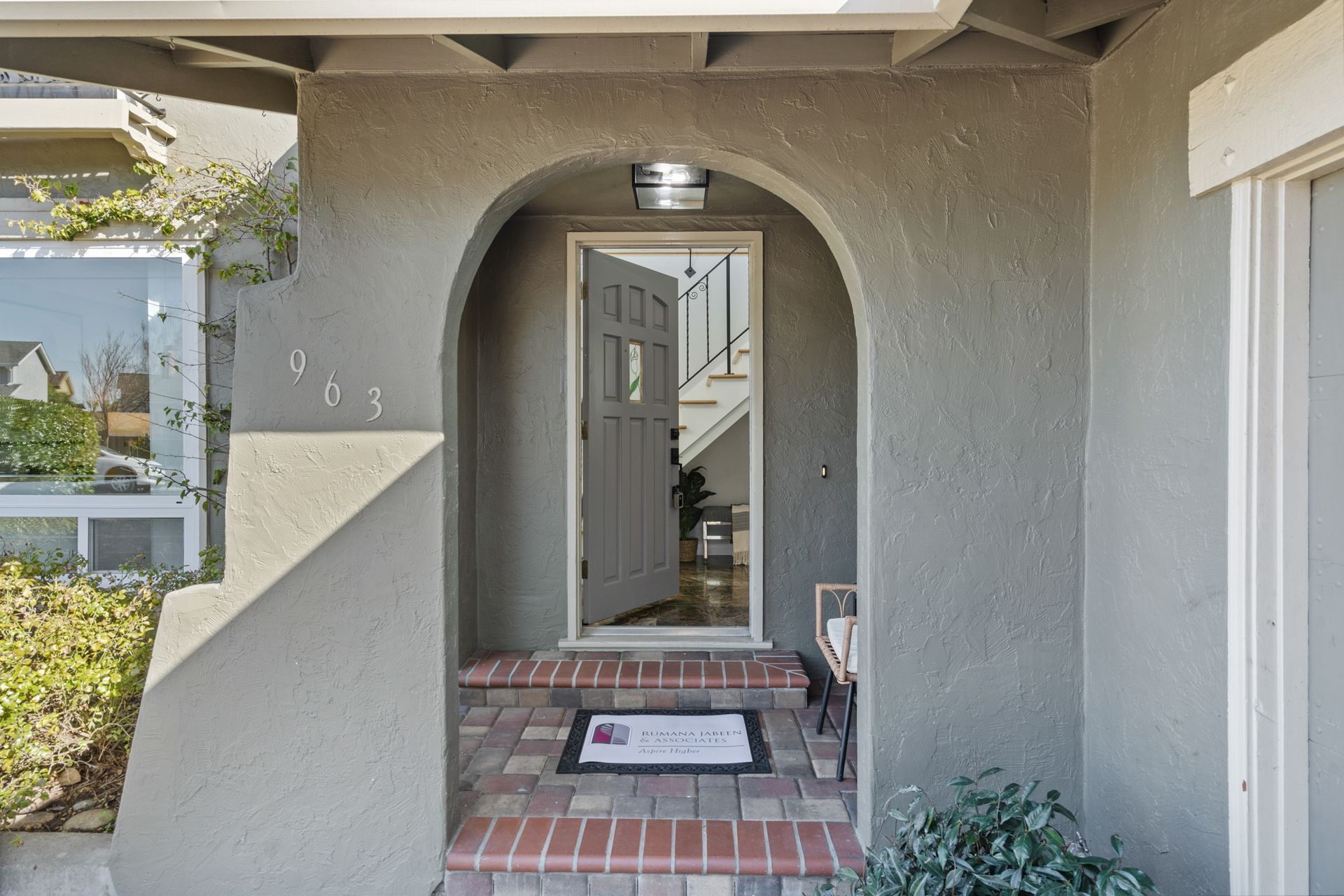 The front door of a house has a brick walkway leading to it