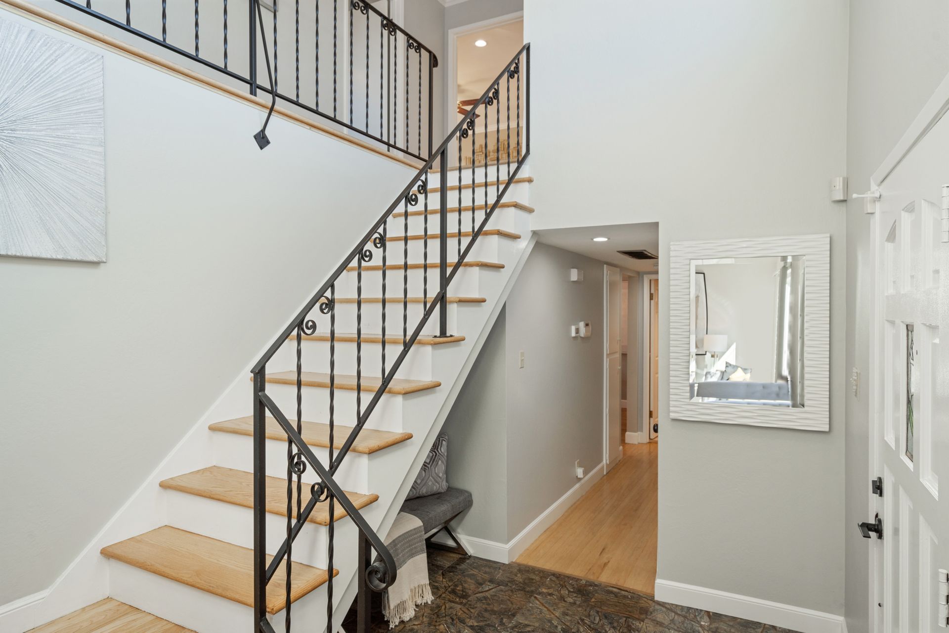 A staircase with a wrought iron railing leading up to the second floor of a house.