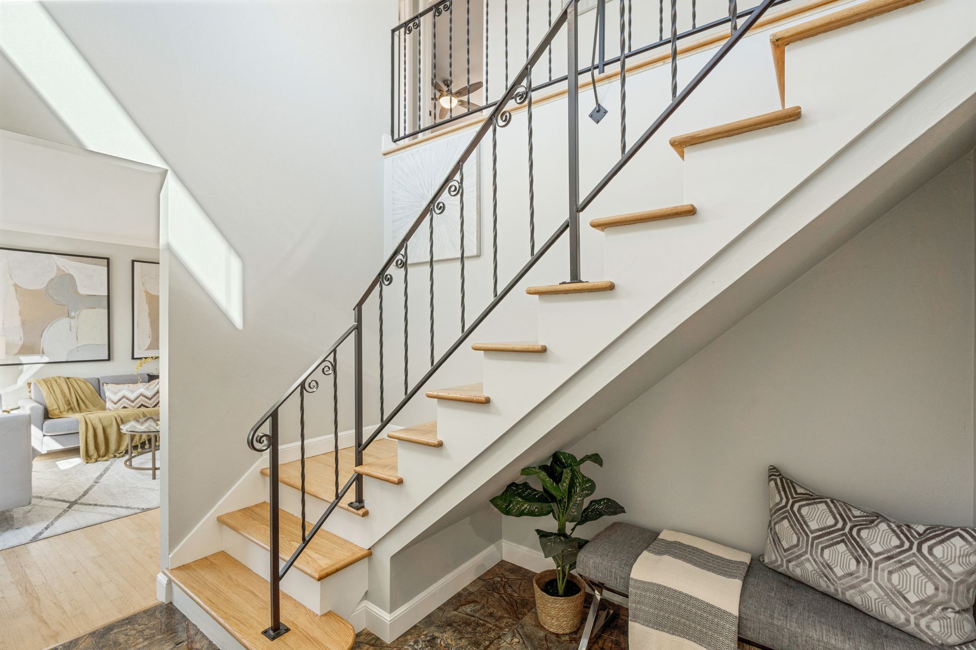 A living room with a staircase leading up to the second floor.