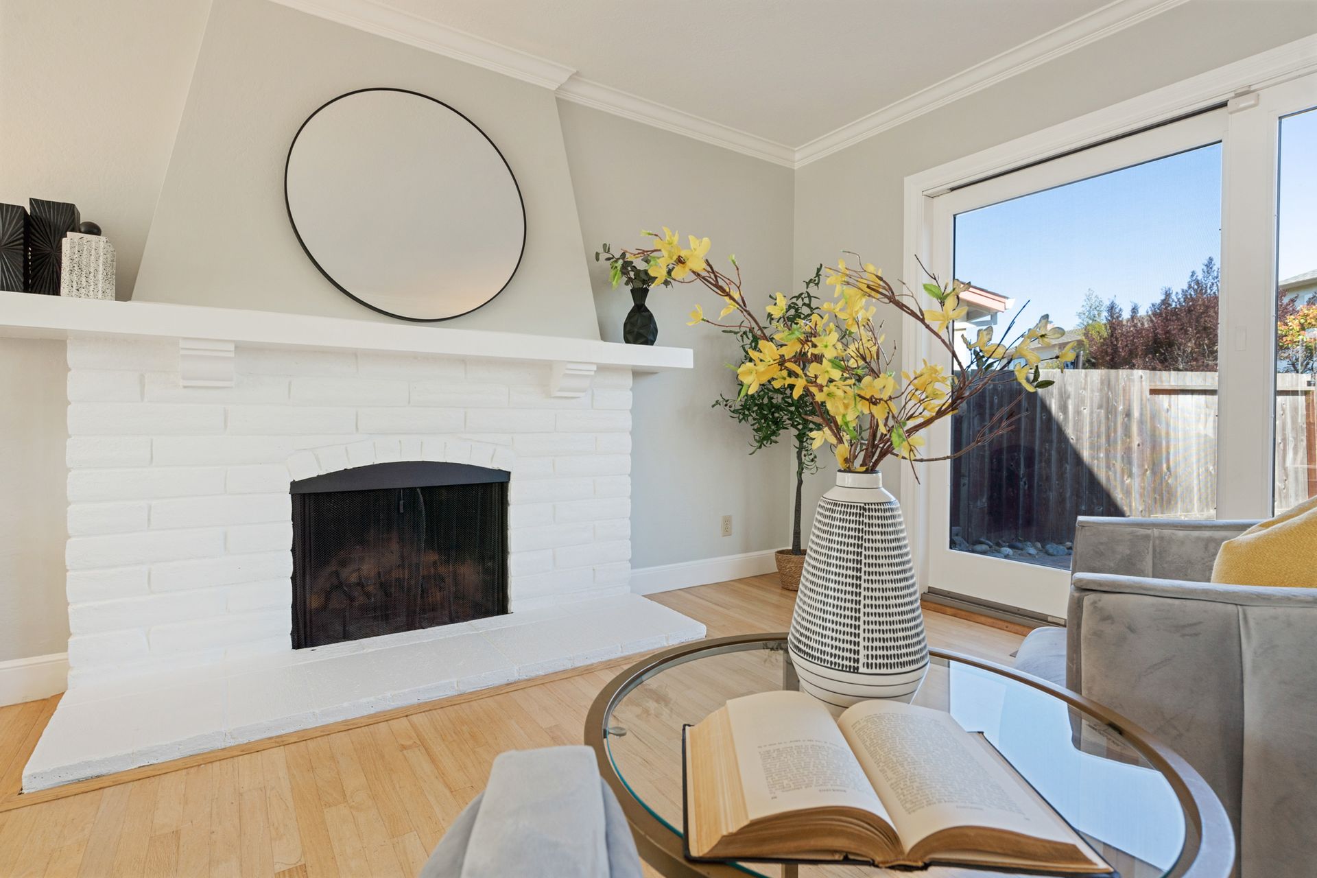 A living room with a fireplace and a book on a table.