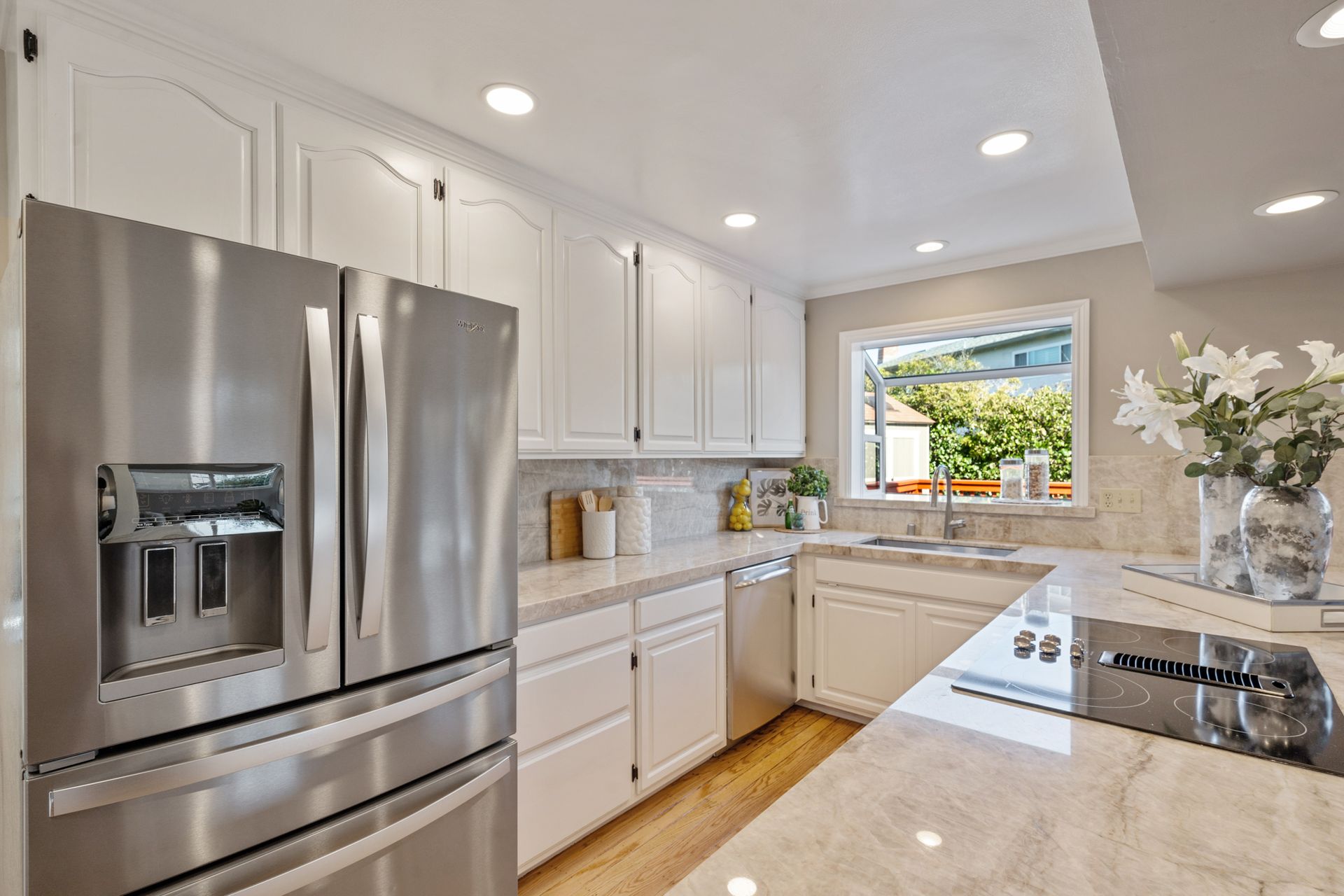 A kitchen with stainless steel appliances and white cabinets.