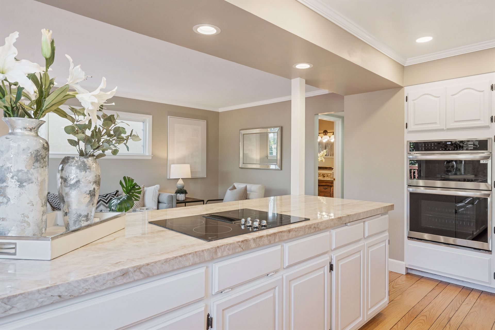 A kitchen with white cabinets , granite counter tops , and stainless steel appliances.