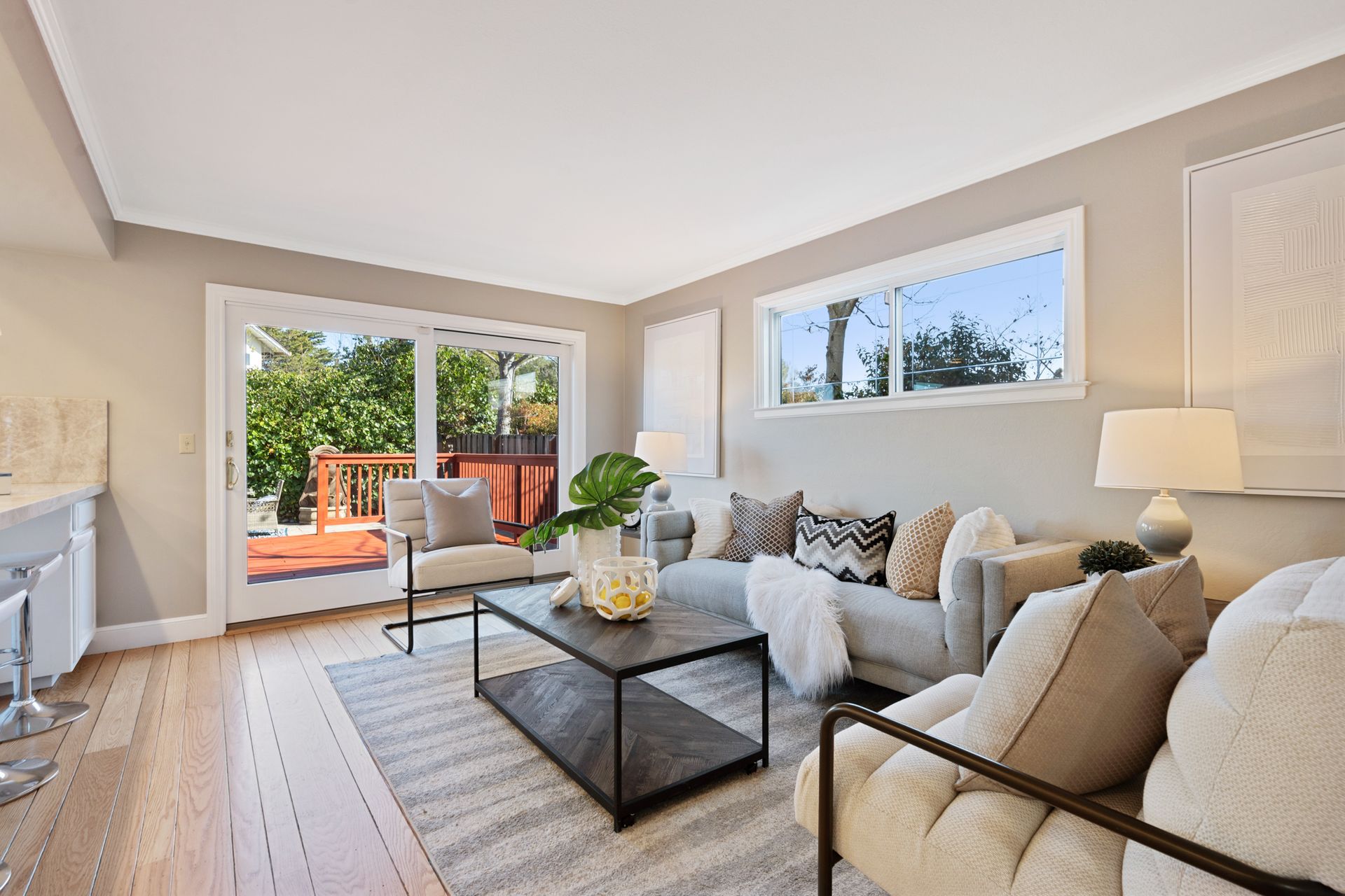 A living room with a couch , chair , coffee table and sliding glass doors.