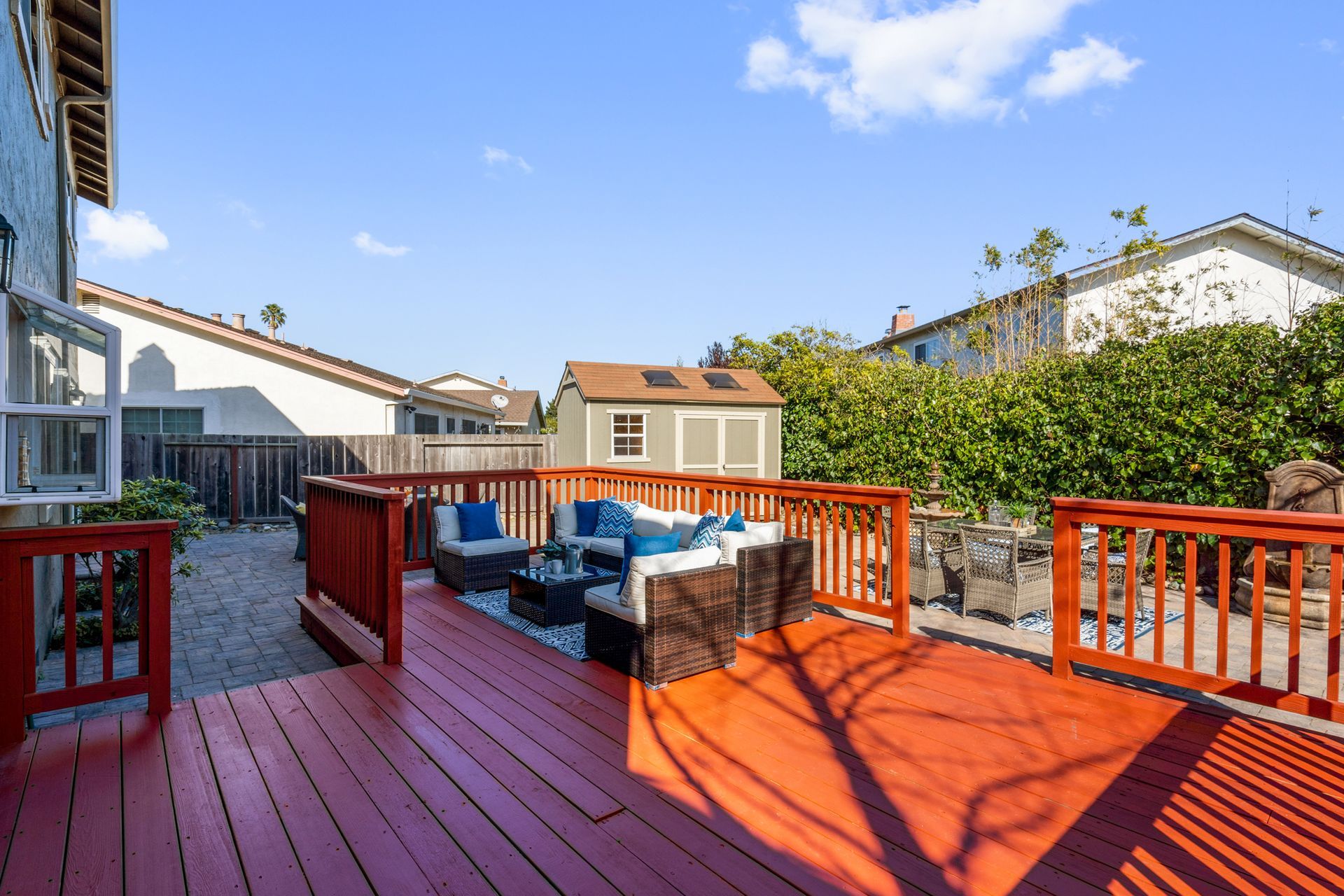 A red deck with a couch and chairs on it