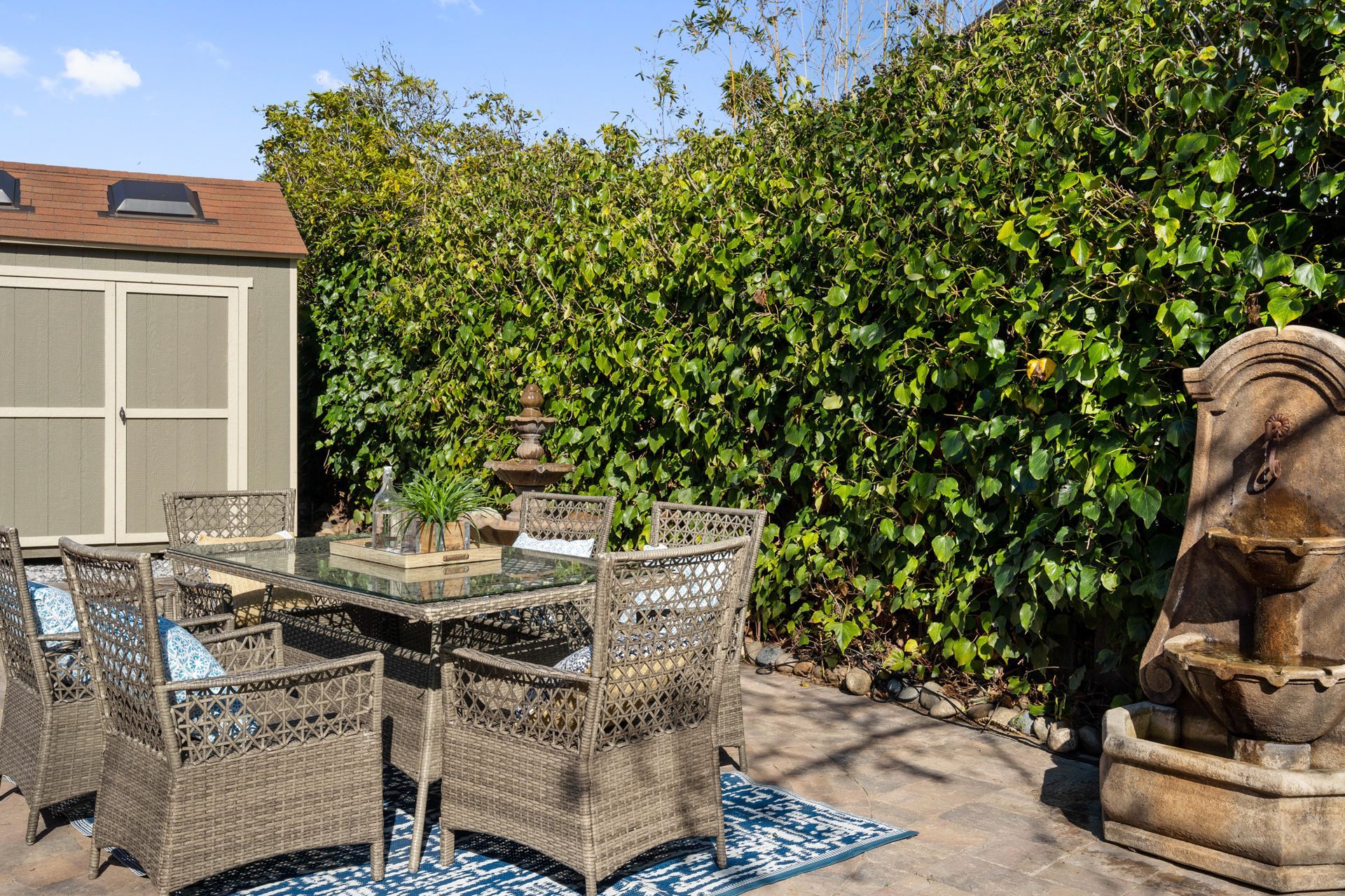 A patio with a table and chairs and a fountain