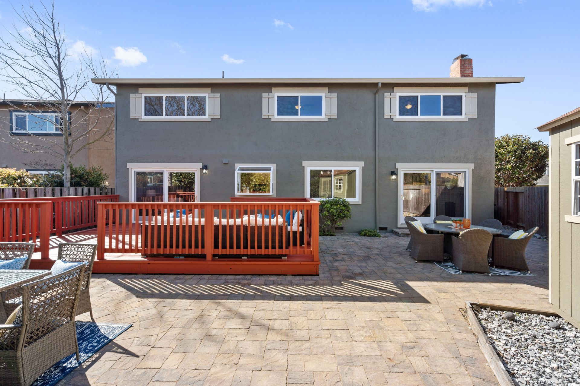 The back of a house with a large deck and patio area
