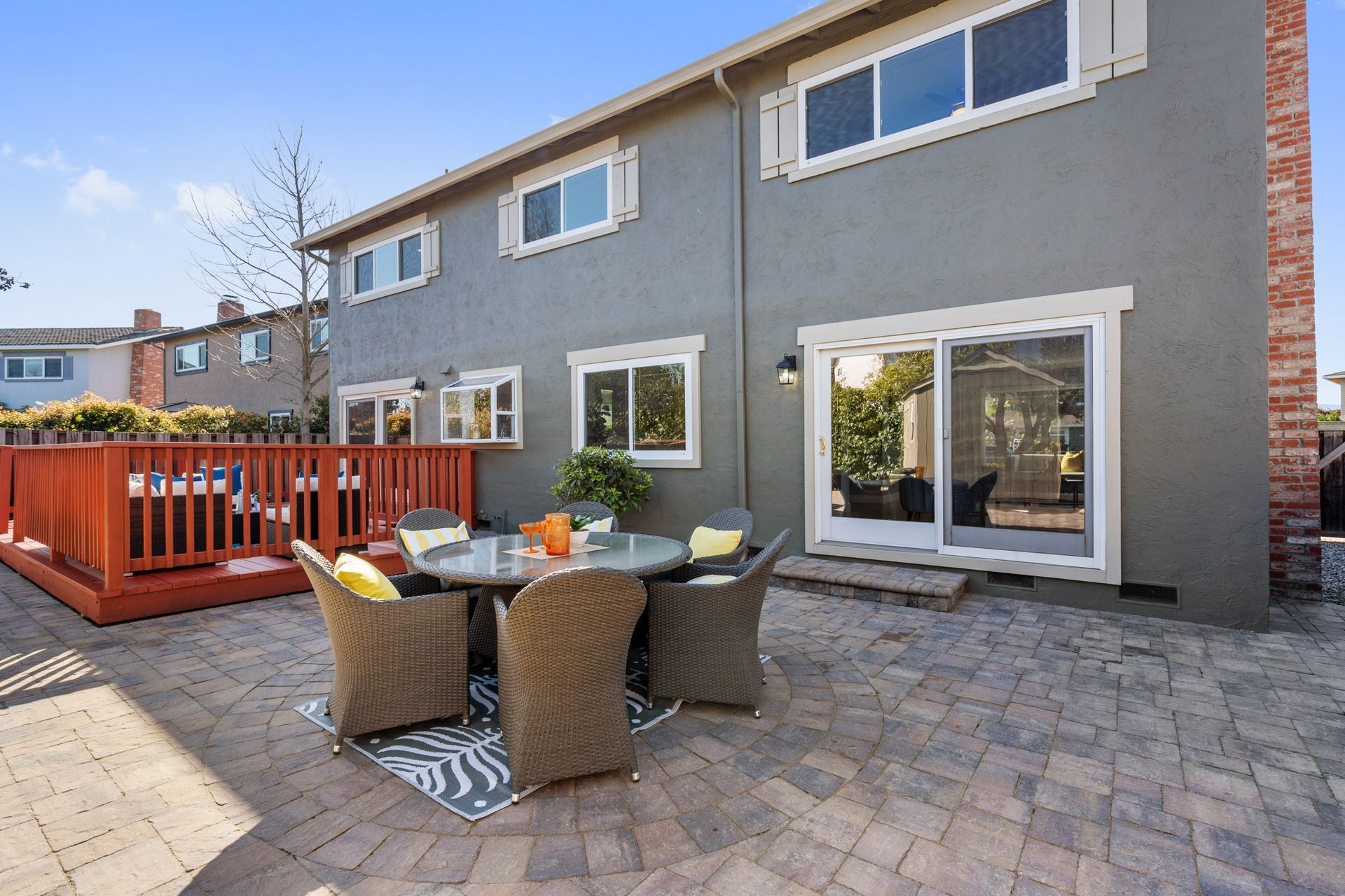 A patio with a table and chairs in front of a house.