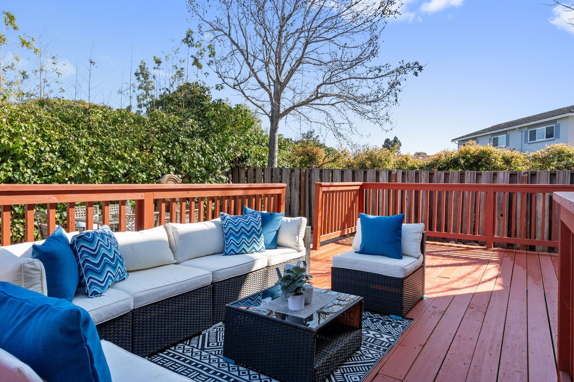 A wooden deck with a couch and a table on it.