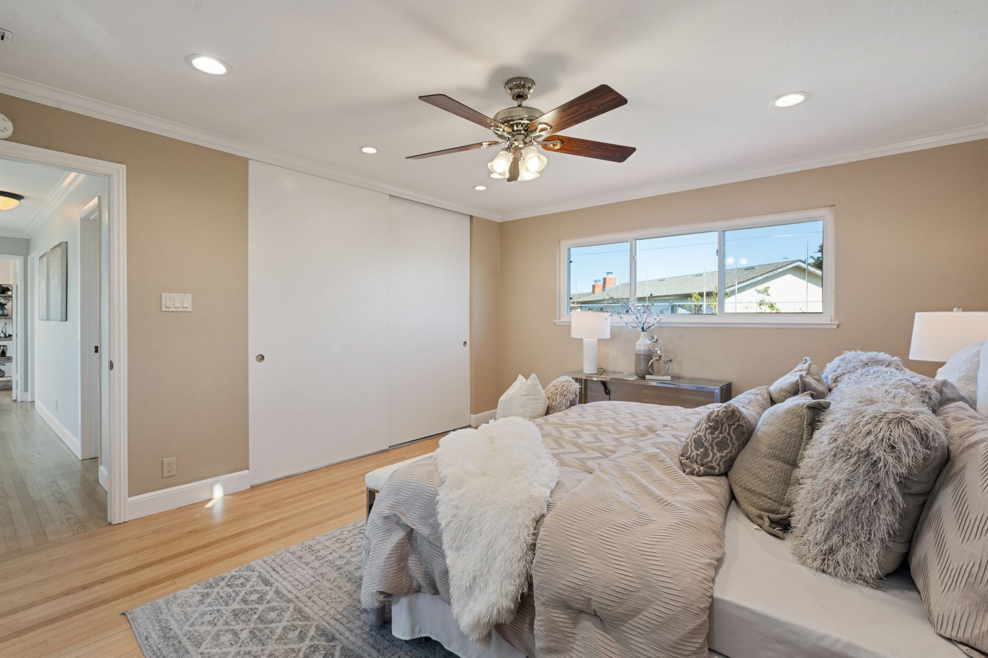 A bedroom with a large bed and a ceiling fan.