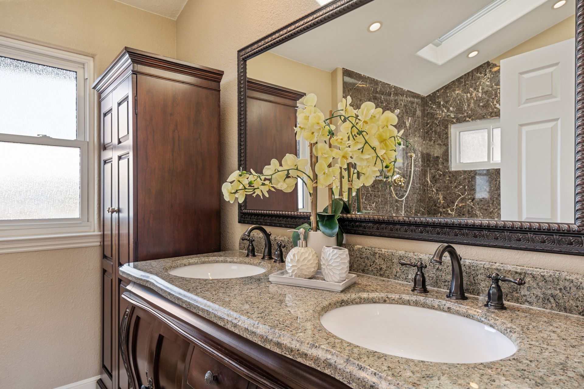 A bathroom with two sinks and a large mirror.