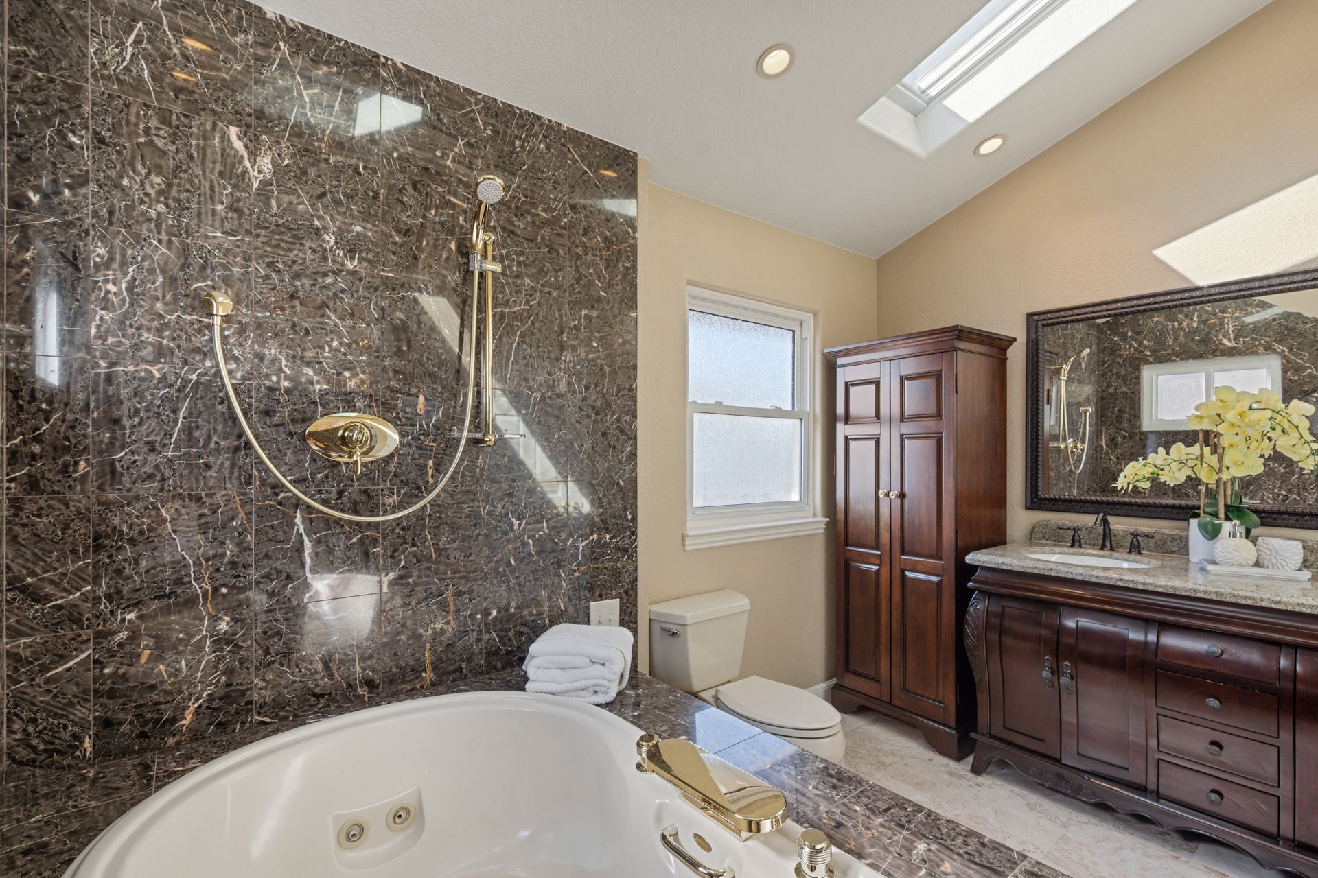 A bathroom with a tub , toilet , sink and mirror
