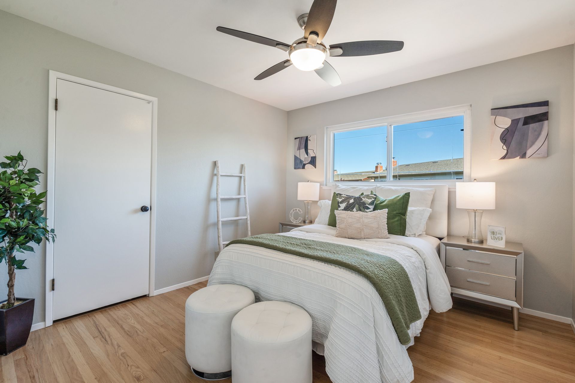 A bedroom with a bed and a ceiling fan.