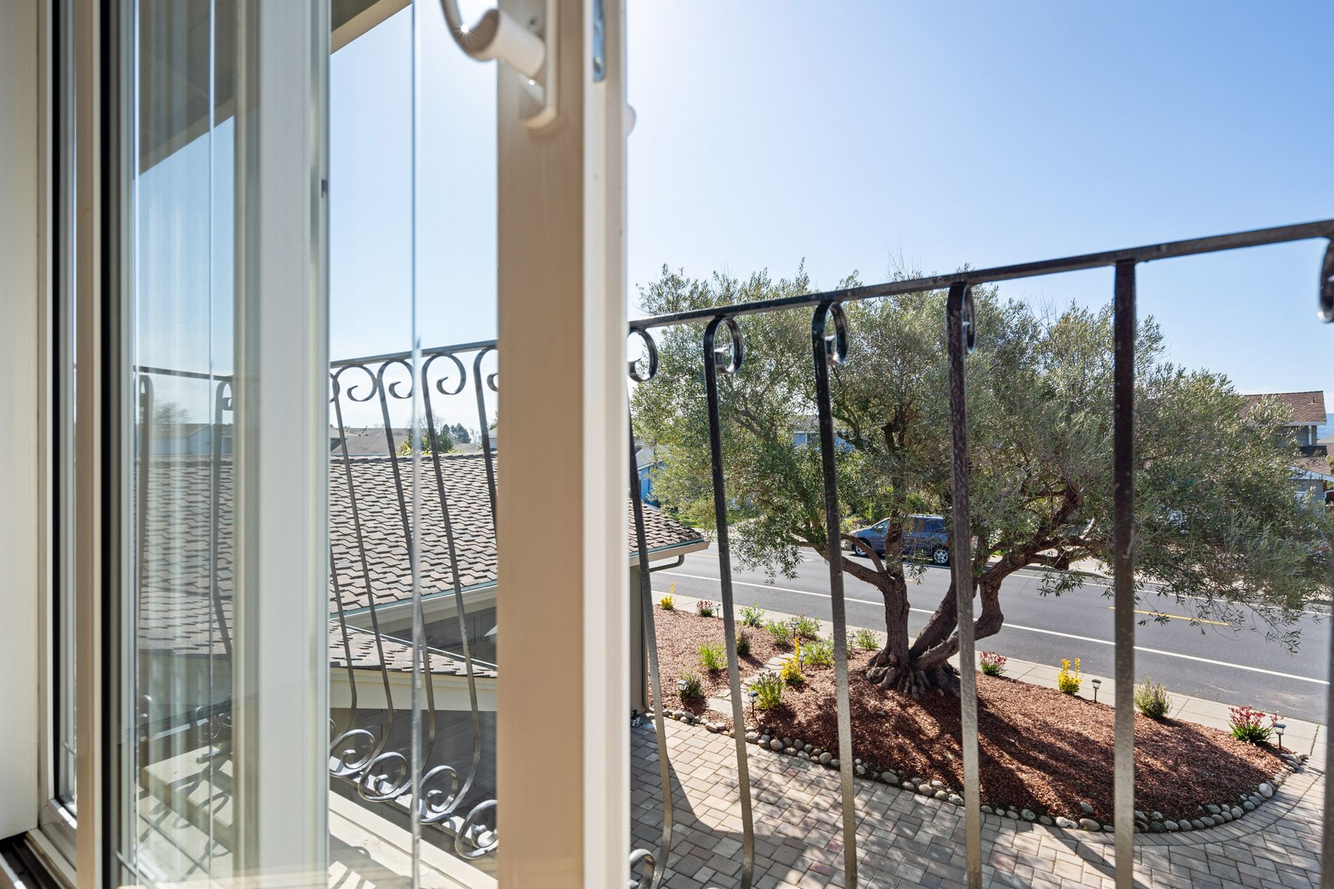 A balcony with a fence and a tree in the background