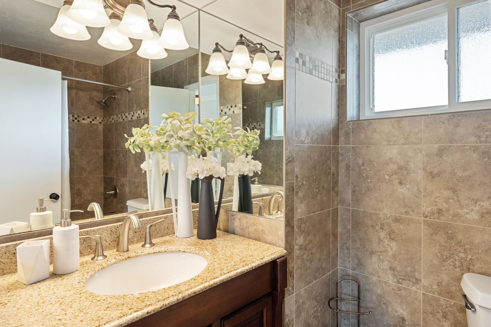 A bathroom with a sink , toilet and mirror.