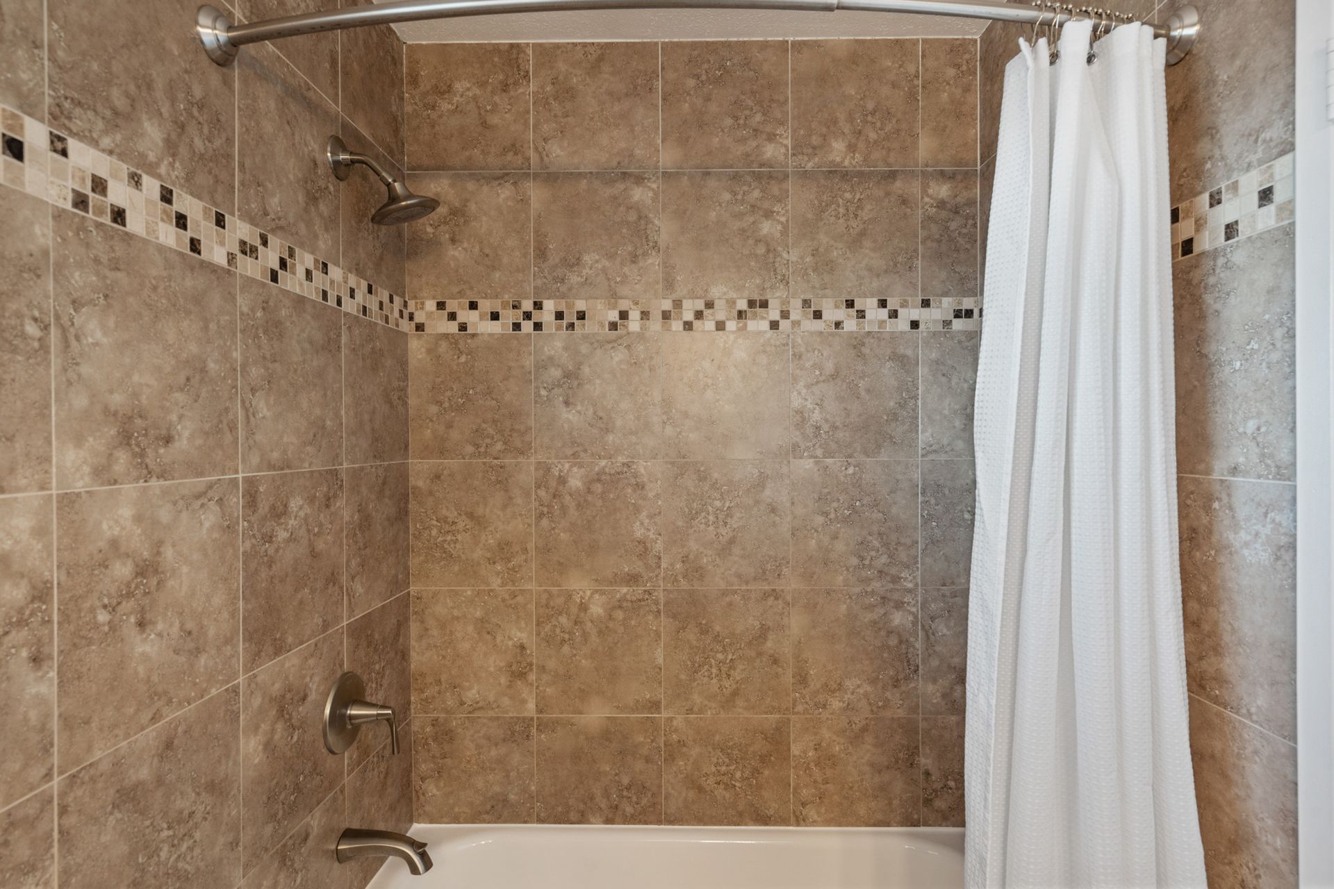 A bathroom with a bathtub and shower curtain.