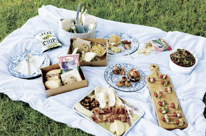 A picnic blanket with a variety of food on it