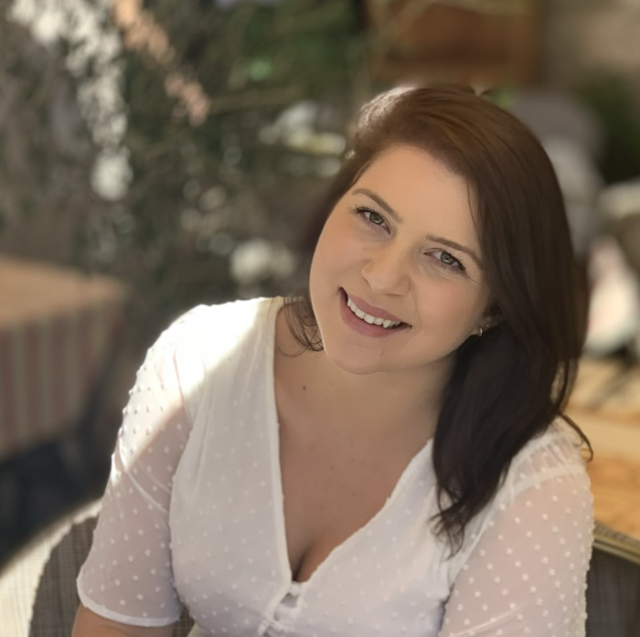 A woman in a white shirt is smiling for the camera