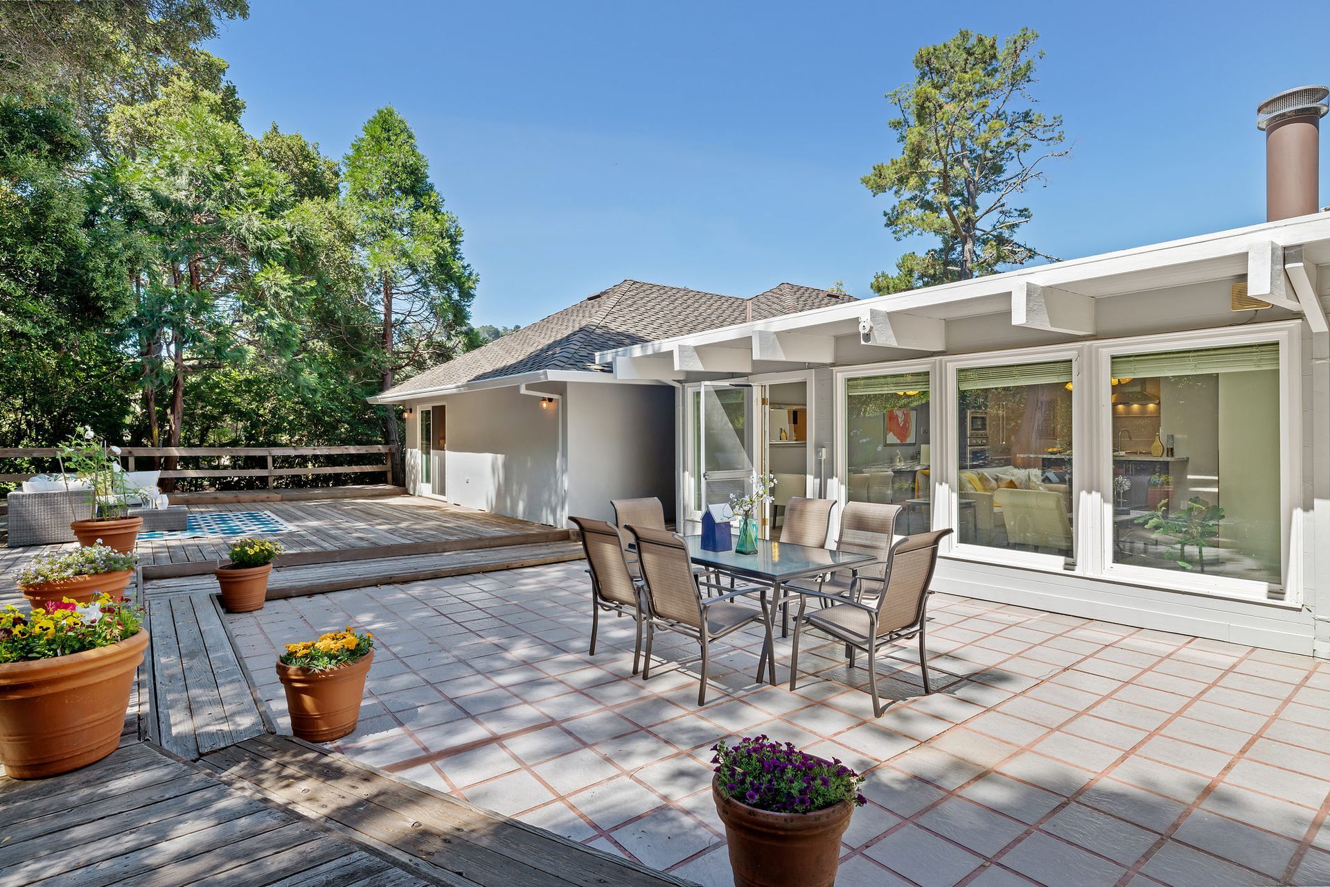 A patio with a table and chairs in front of a house