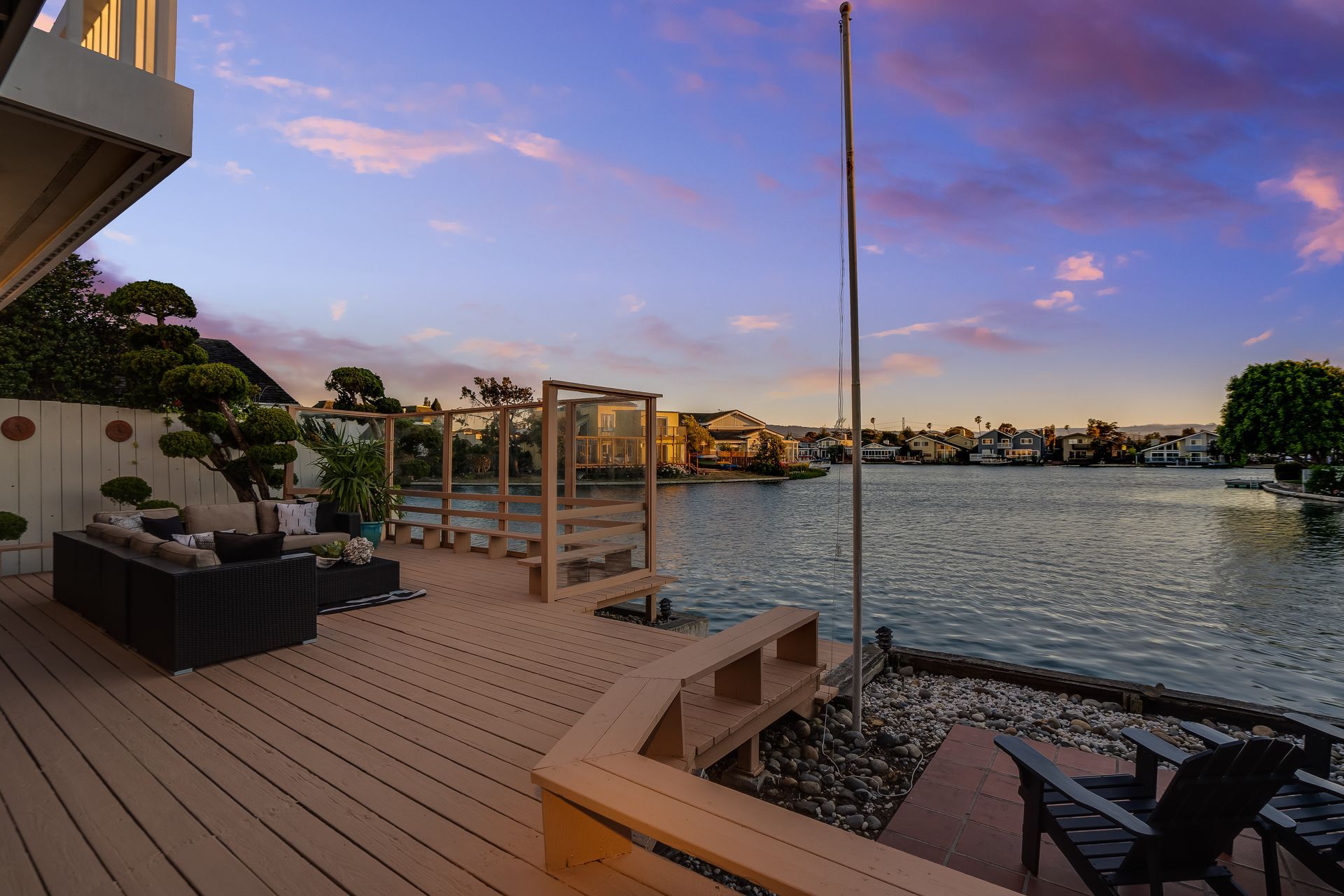 A wooden deck overlooking a body of water at sunset