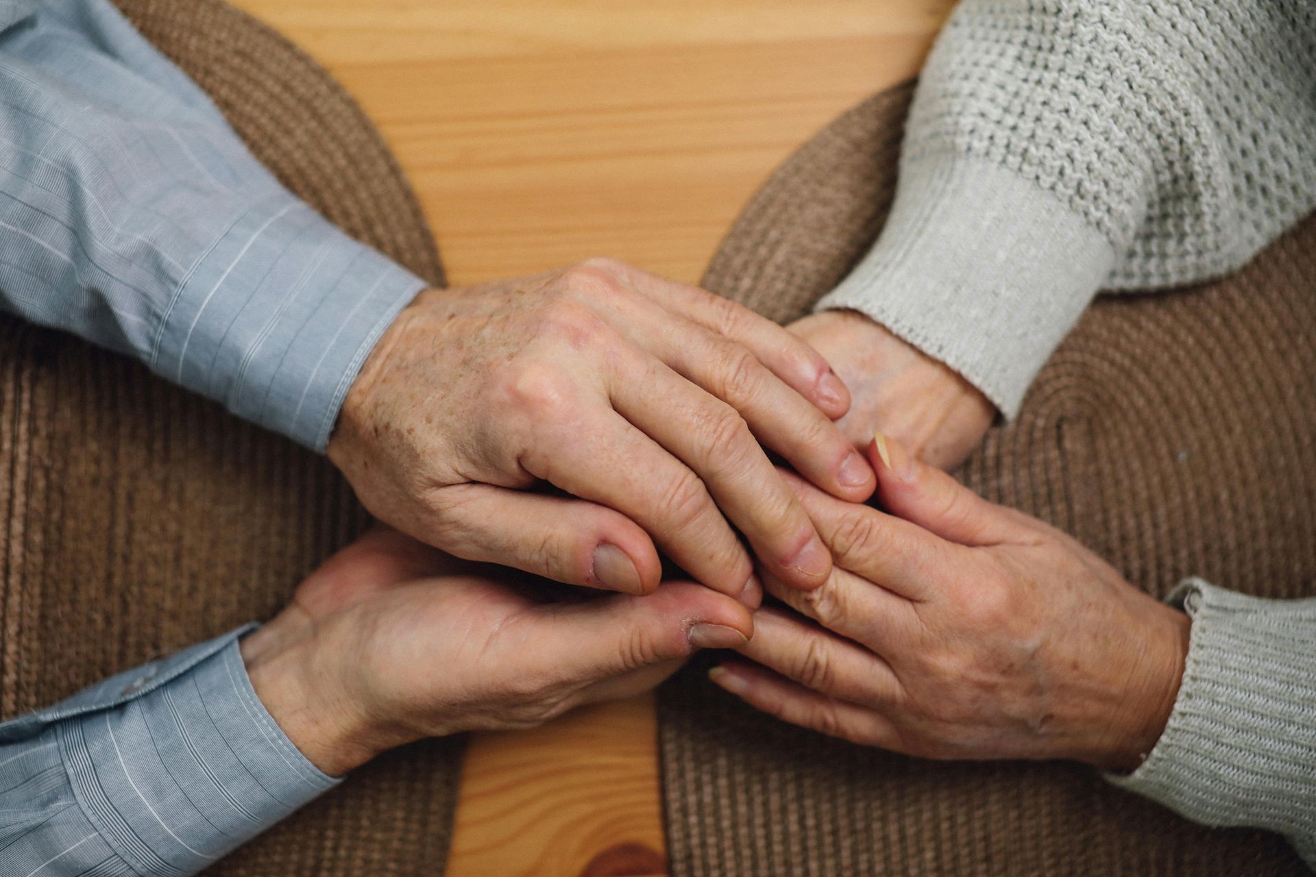 Two people holding hands, offering comfort and support.
